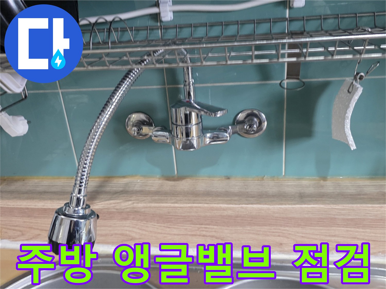 싱크대 벽면 수도 밸브와 연결 호스 근접 사진