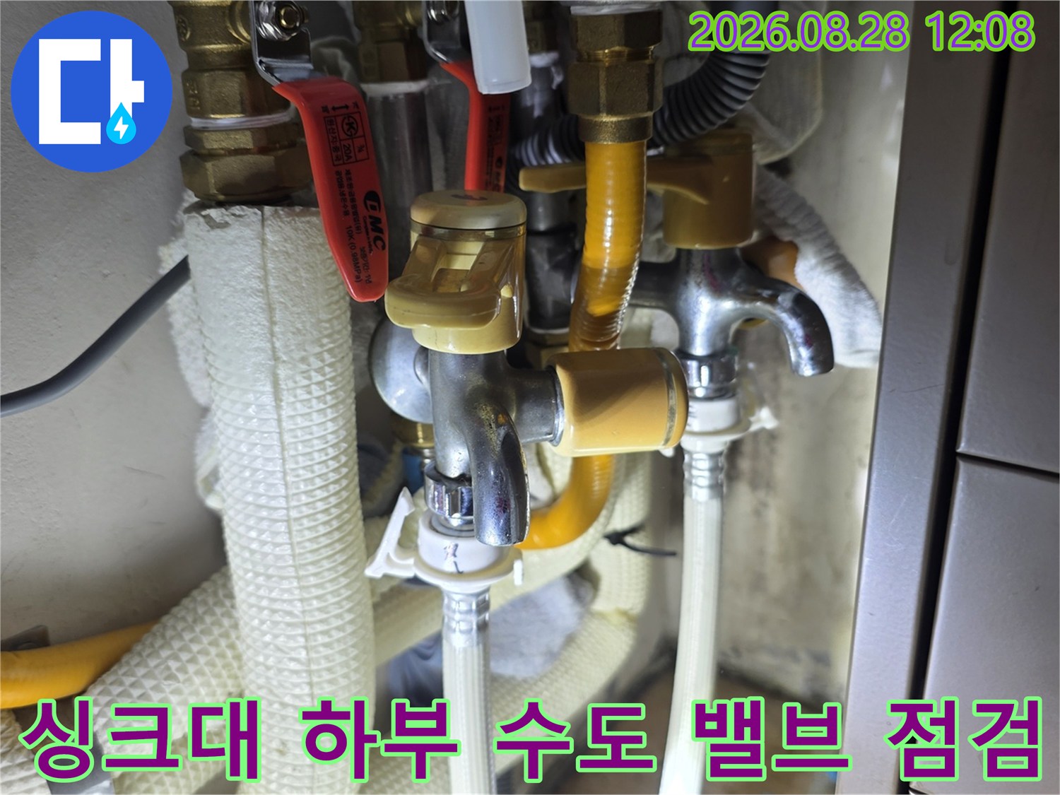 싱크대 아래 설치된 금속 밸브와 노란색 보온재 배관 연결 상세