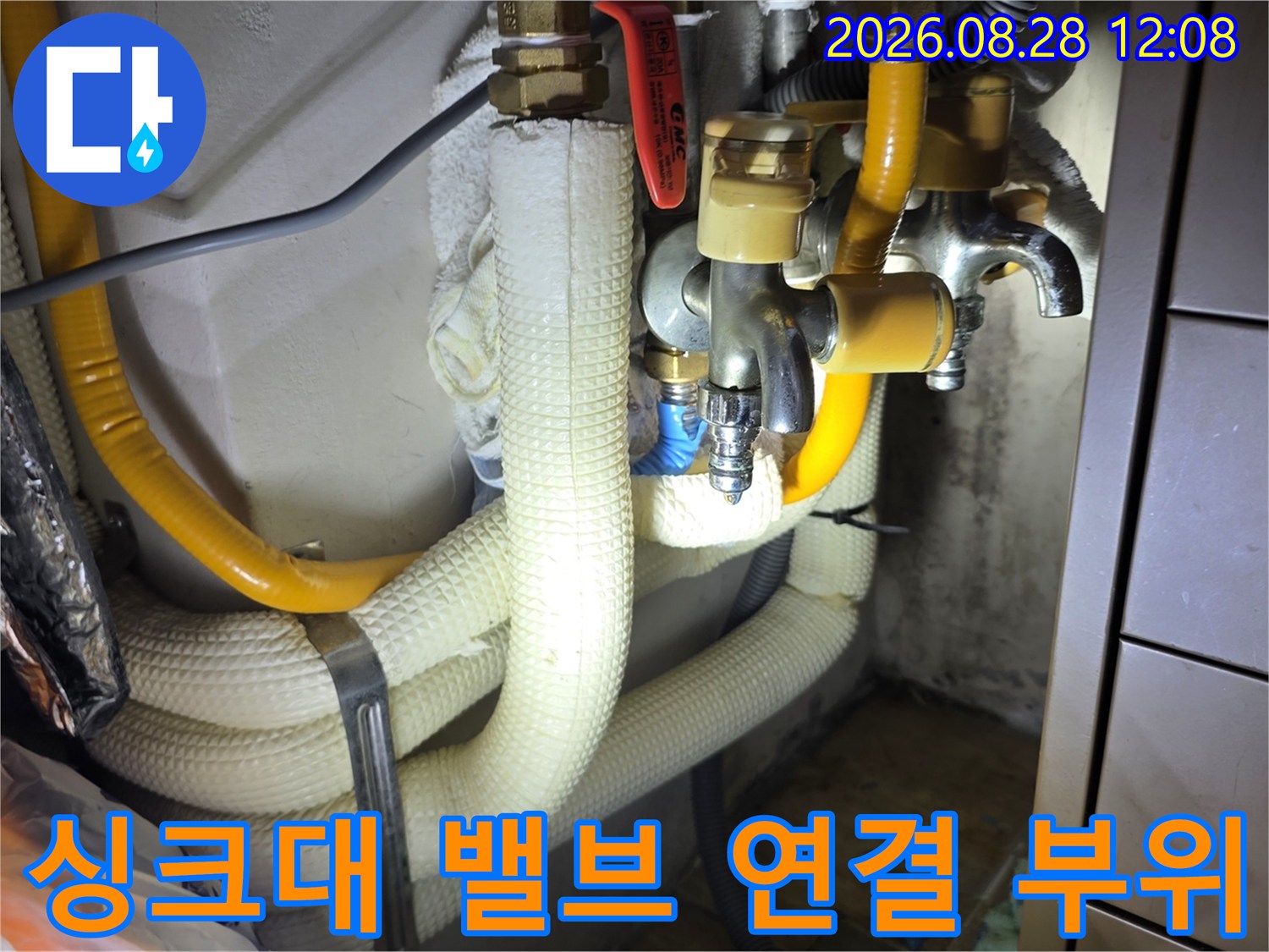 싱크대 하부 금속 밸브와 노란색 배관의 결합 상태를 보여주는 사진
