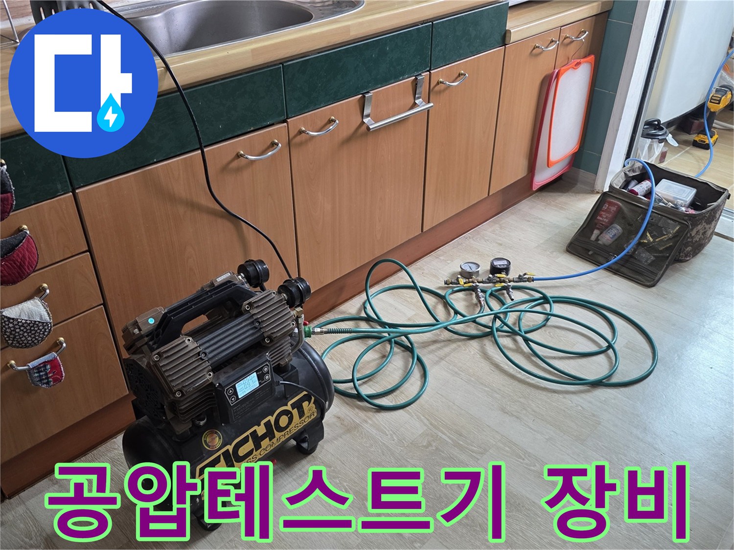 싱크대 하부장 근처에 배치된 배관 압력 점검용 공압 테스트기