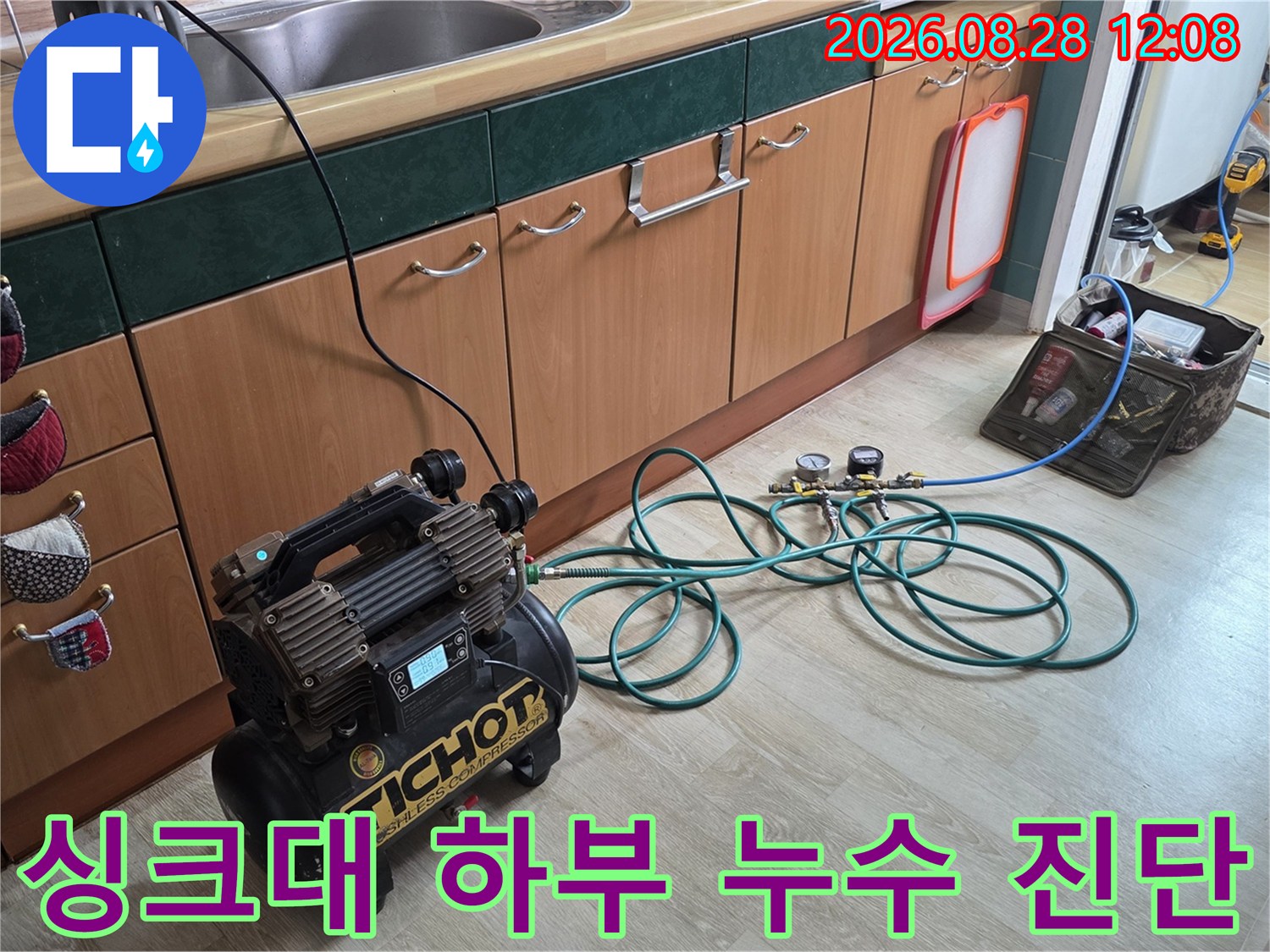싱크대 하부장 바닥 배관에 연결된 전문 공압 테스트 장비