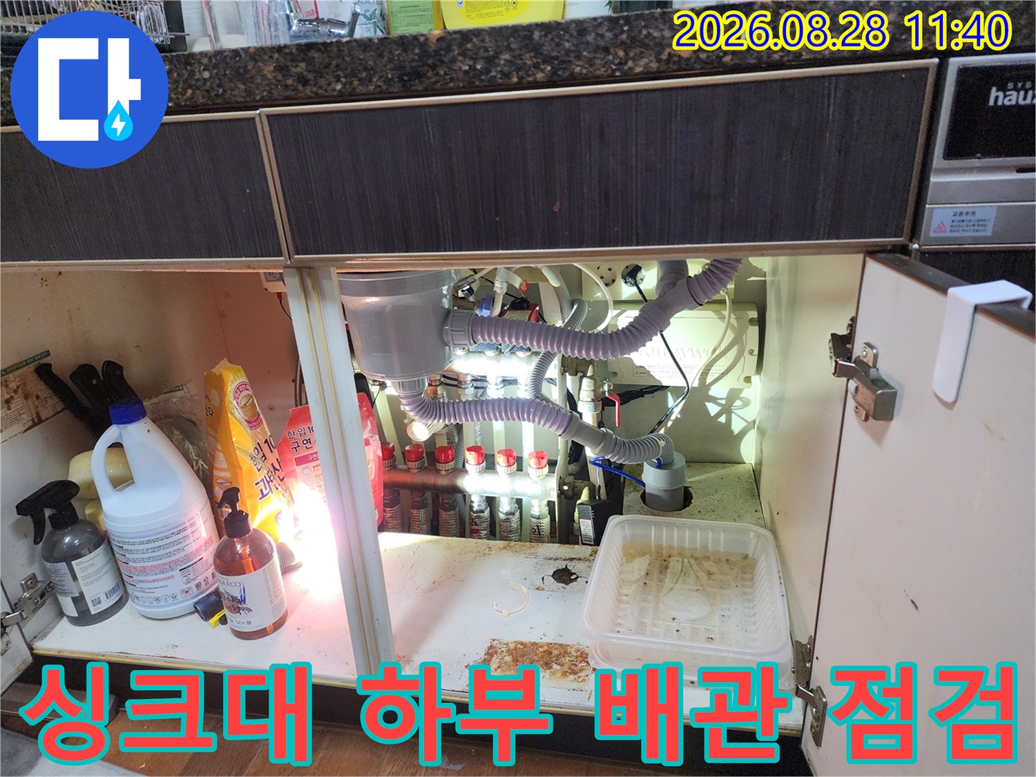 싱크대 밑 공간에 노출된 에어컨 드레인 호스와 각종 배관들의 연결 상태