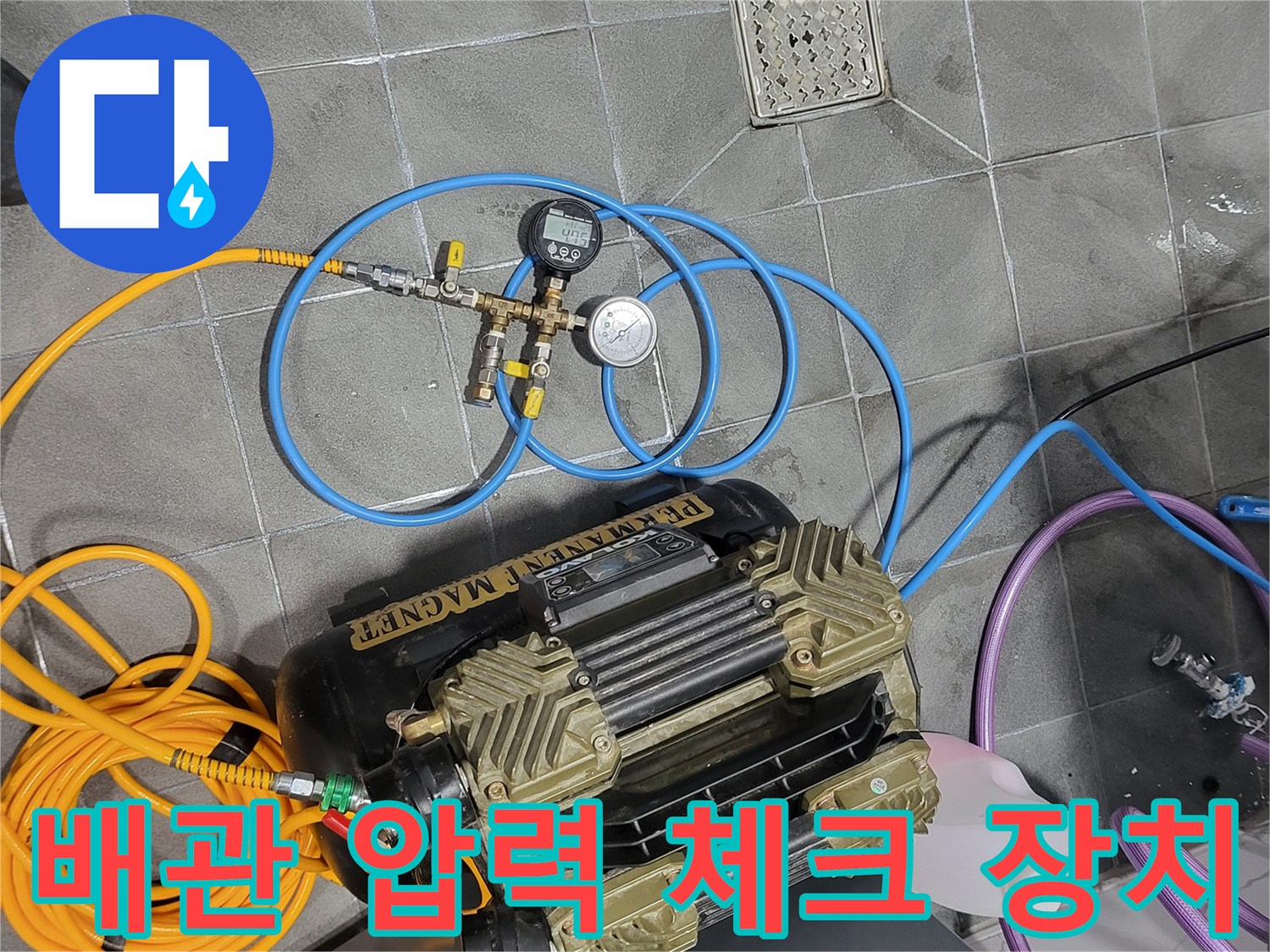 바닥 타일 위 압력계와 연결된 노란색 및 파란색 호스