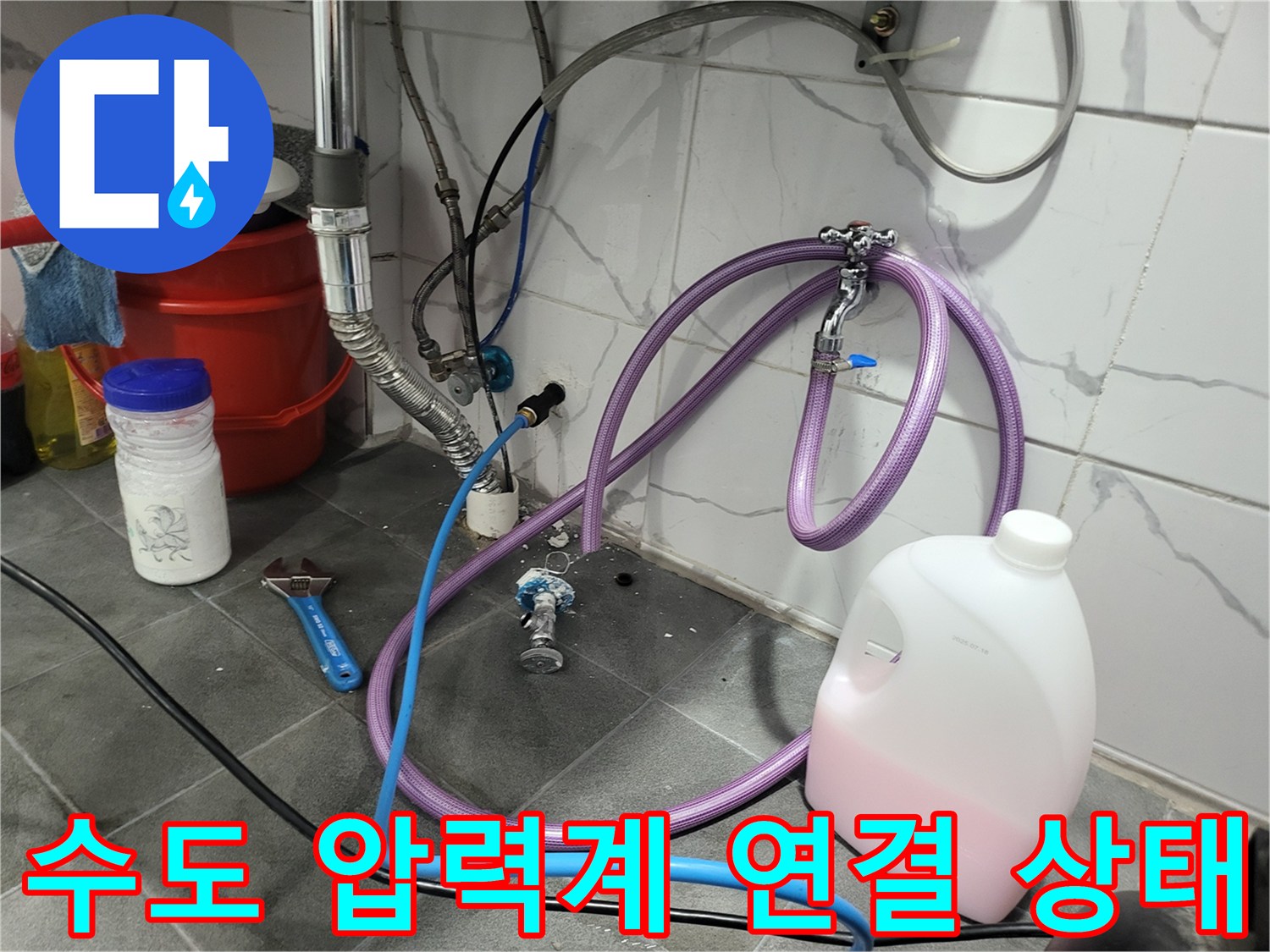 배관 밸브와 연결된 보라색 호스 및 압력 측정 장치
