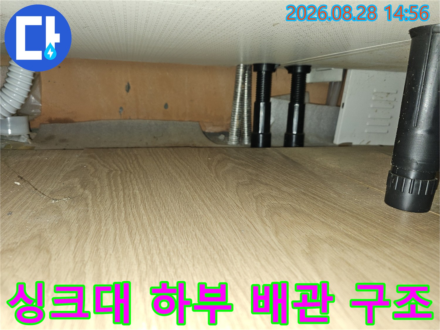 싱크대 아래쪽 주름관과 검은색 배관 지지대 모습
