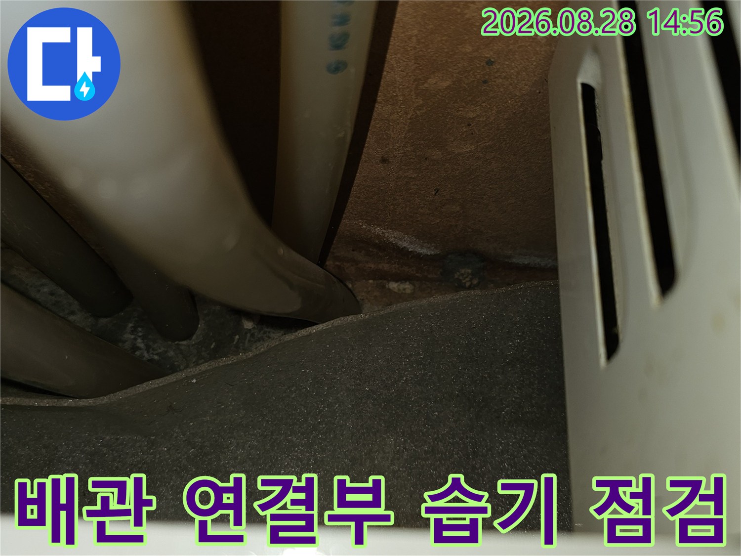 싱크대 하단 배관 사이의 틈새와 연결 부위를 근접 촬영한 사진입니다.