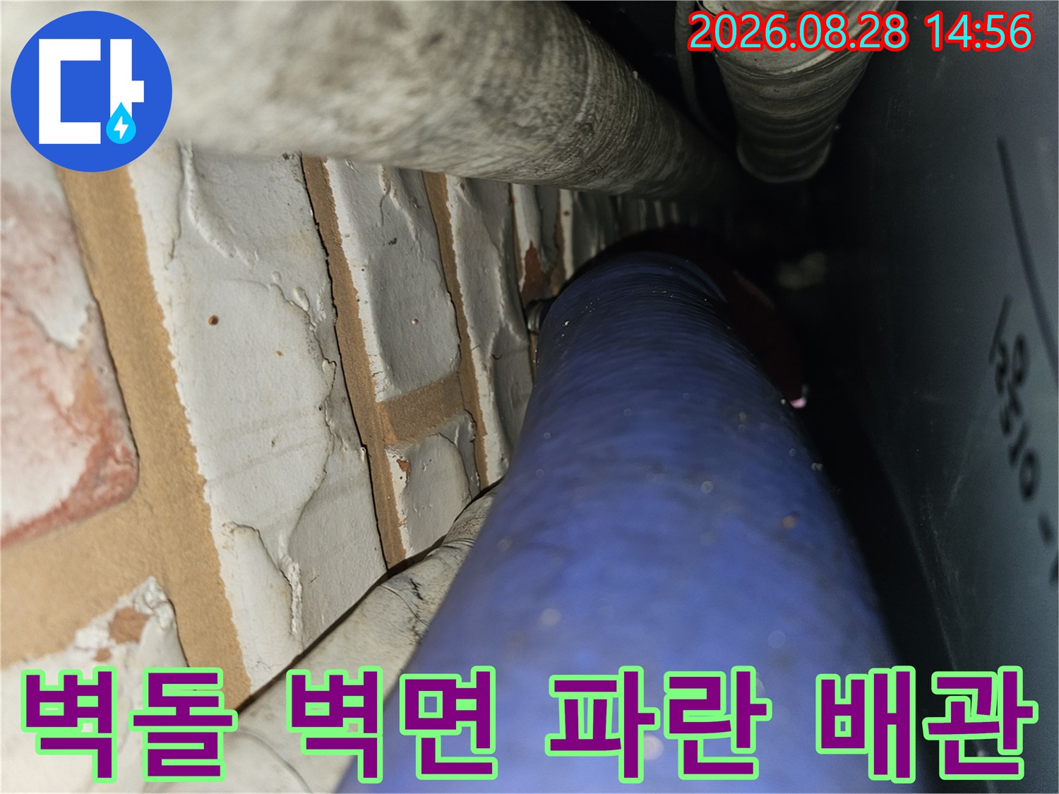 직동리 현장의 벽돌 벽과 파란색 수도 배관이 인접한 모습
