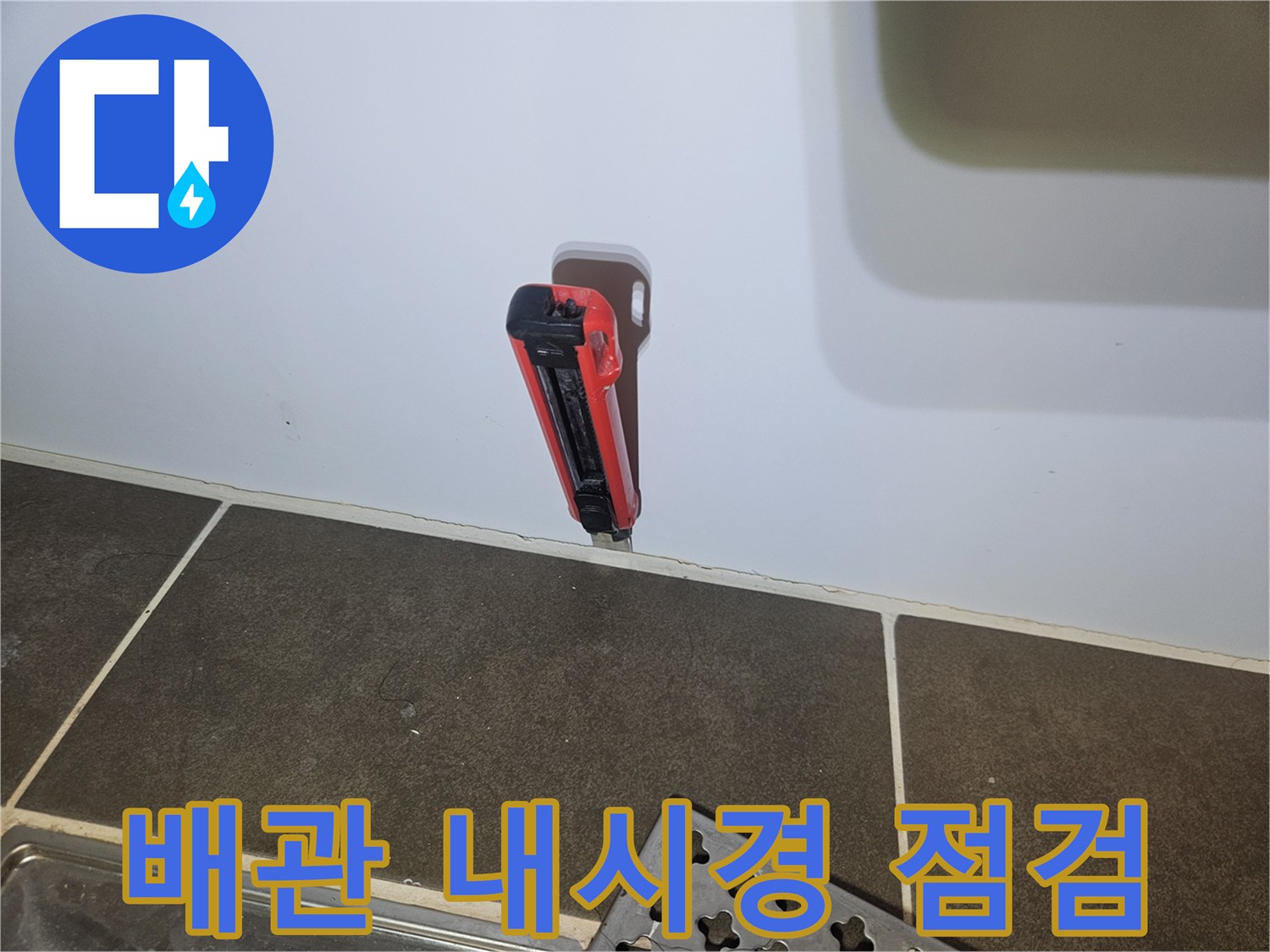 화장실 벽면 타공 부위에 투입된 배관 내시경 카메라의 모습