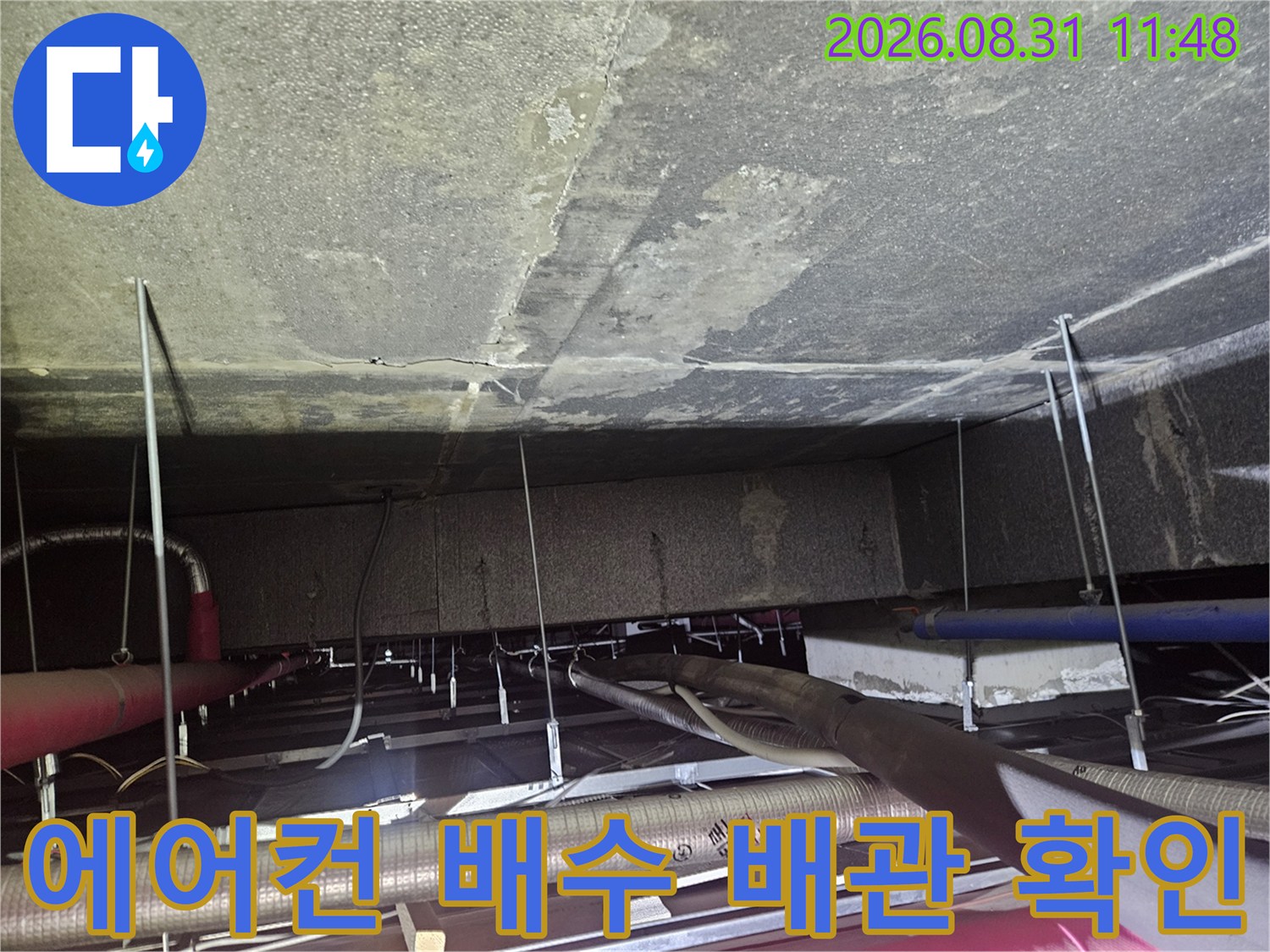 천장 내부의-에어컨 드레인 호스와 얽혀있는 배관들을 보여줍니다.