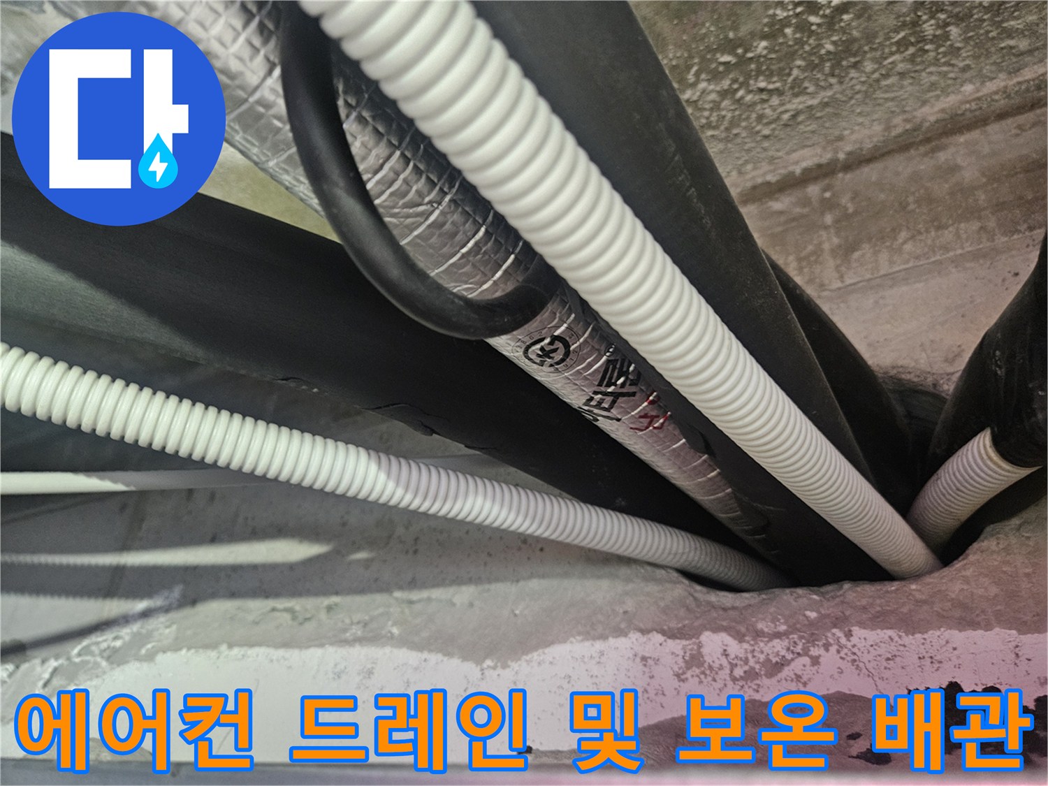 하얀색 주름관과 검은색 보온재가 섞여 있는 천장 내부 배관 모습