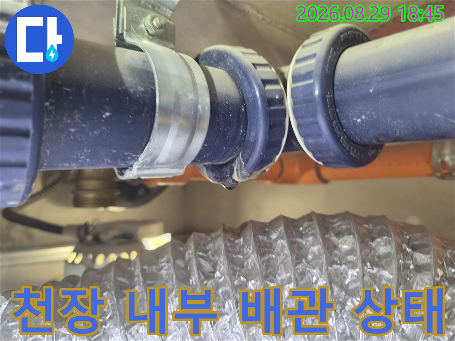 욕실 천장 안쪽 파란색 배관과 금속 클램프의 연결 부위 상세