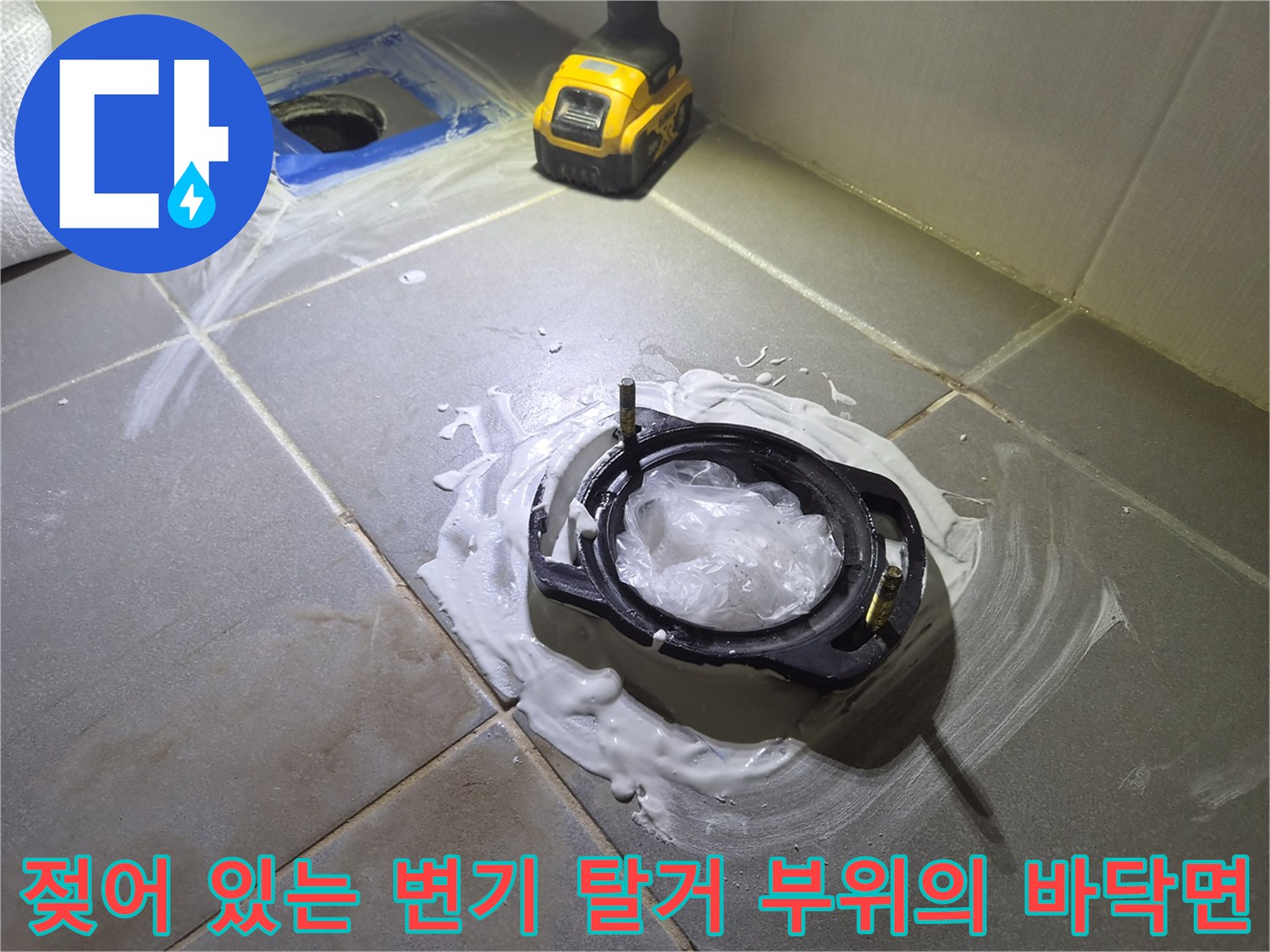 변기를 들어낸 자리 배관 주변에 물이 고여 있고 타일이 젖은 사진입니다.