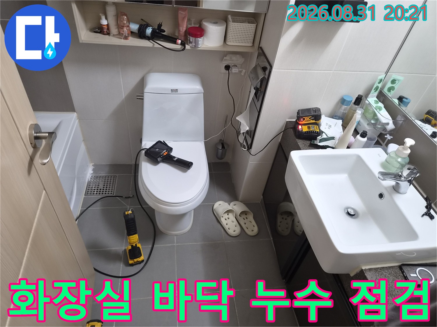 변기와 세면대 주변의 누수 가능성을 확인하기 위해 장비를 활용하여 검사 중입니다.