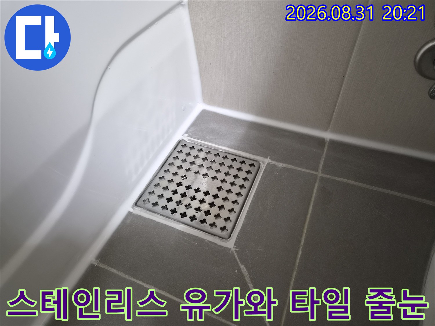 회색 욕실 타일과 스테인리스 배수구 덮개 상세 사진