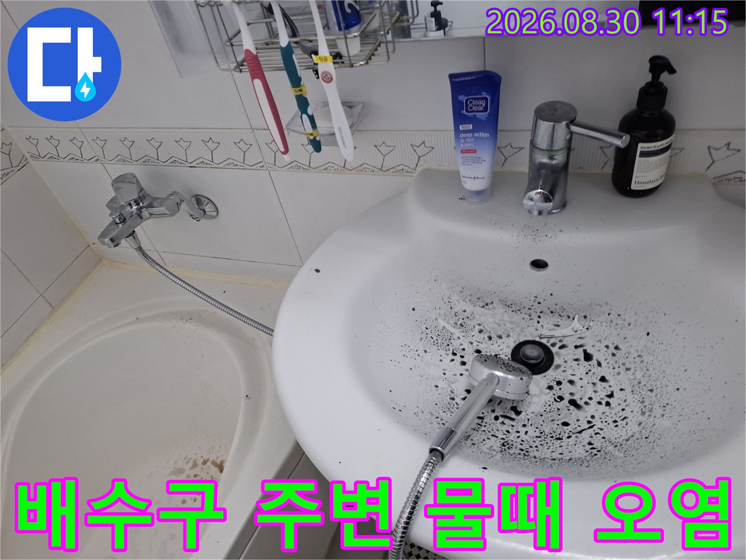 세면대 배수구 근처에 넓게 퍼진 검은색 곰팡이와 오염 물질 상태