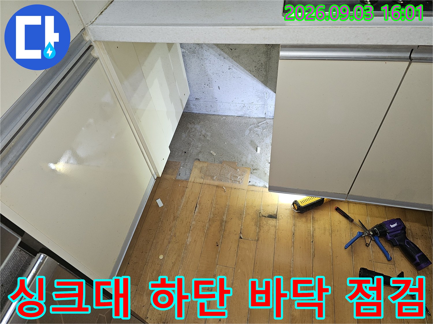 분당 백현동 아파트 싱크대 하부장 아래 노출된 바닥과 작업 도구들