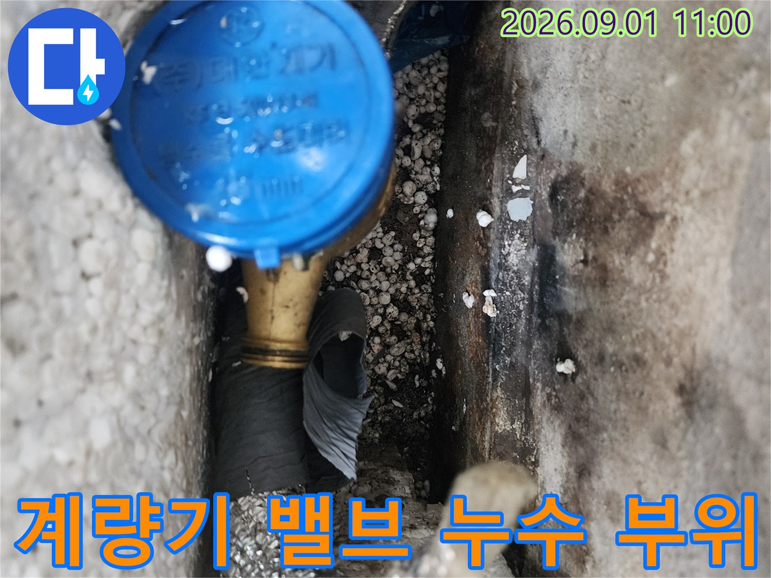 파란색 계량기 밸브와 배관 연결부의 누수 흔적 사진