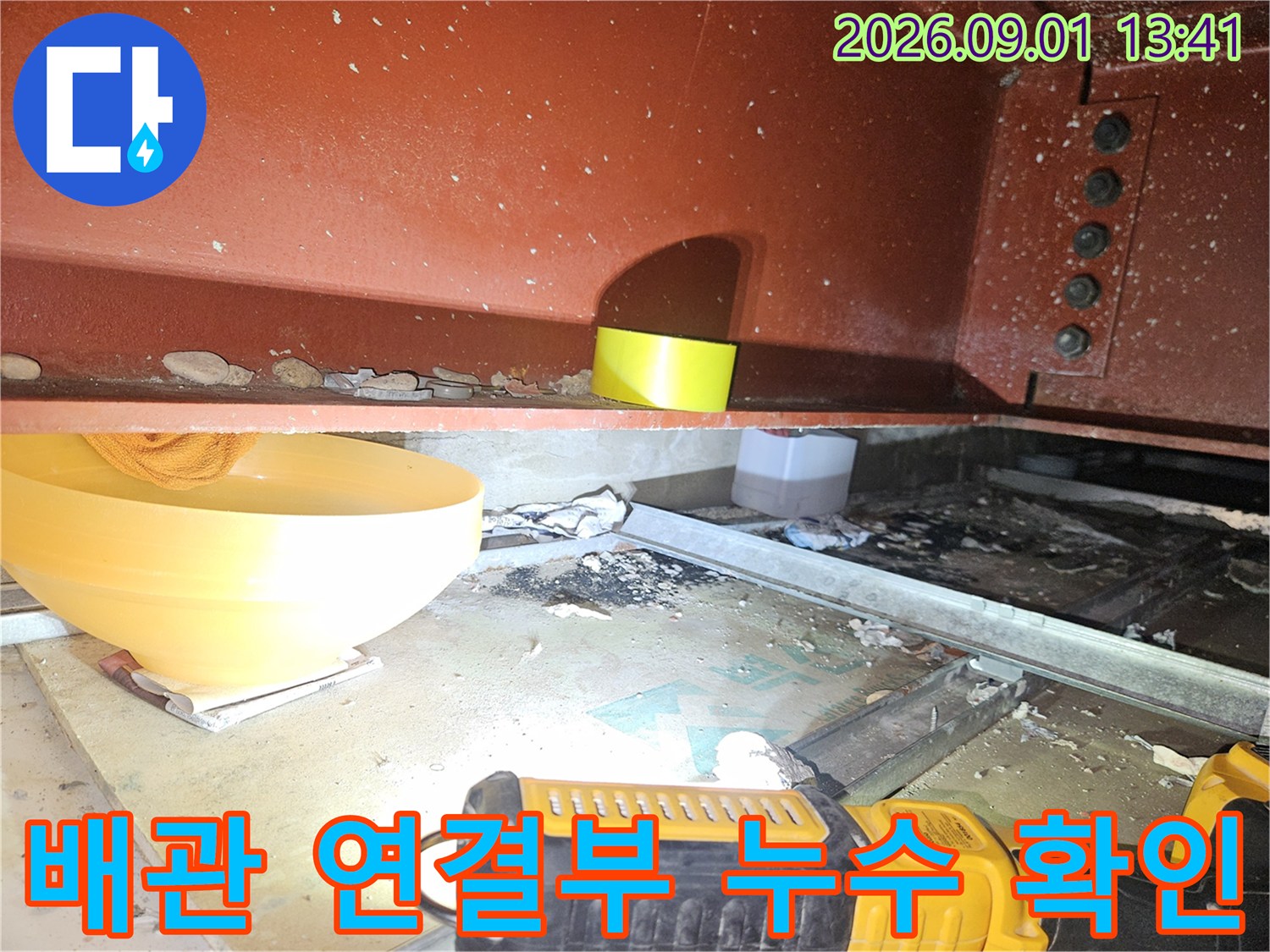 천장 구조물 사이의-붉은색 배관과 주변 습기 상태를 촬영한 사진입니다.