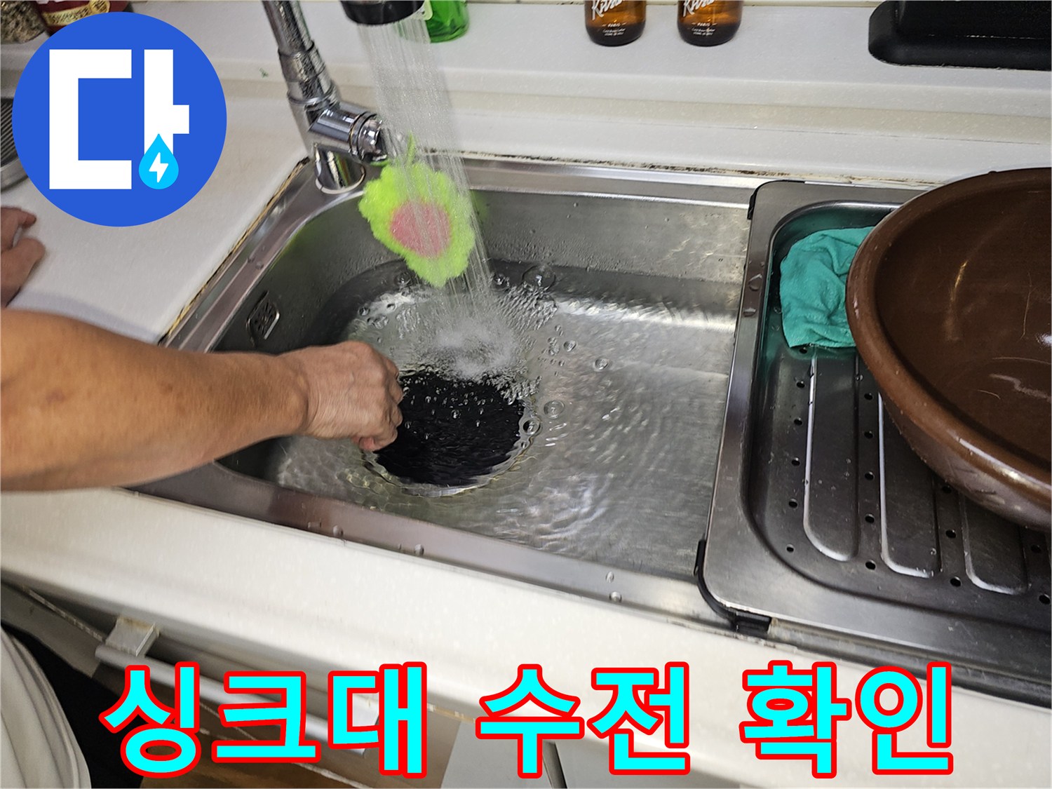 싱크대에서 물을 틀어 배수 상태와 누수 여부를 관찰하는 장면