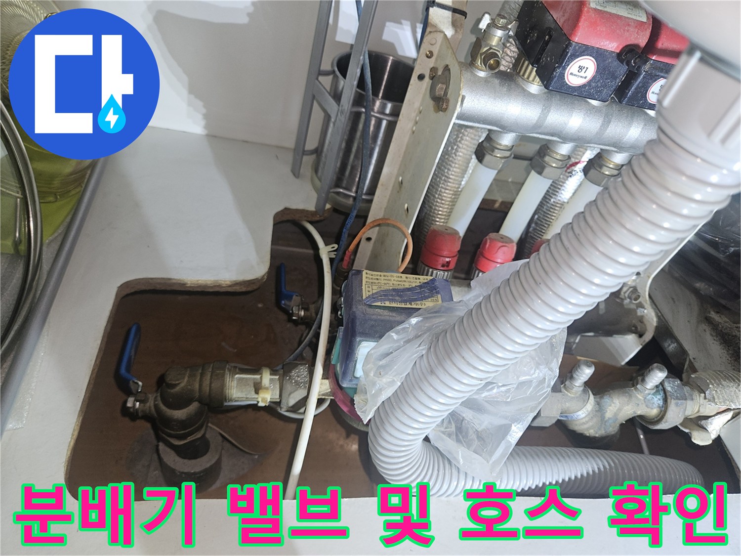 보일러 분배기에 연결된 주름관과 금속 밸브의 상세 모습입니다.