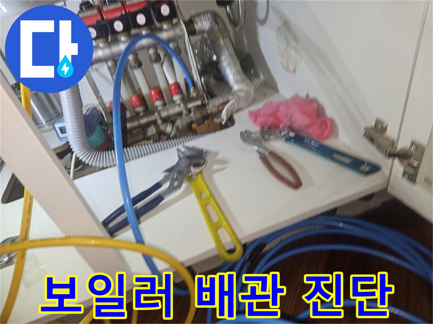 복잡하게 연결된 보일러 분배기 부위와 점검 도구들