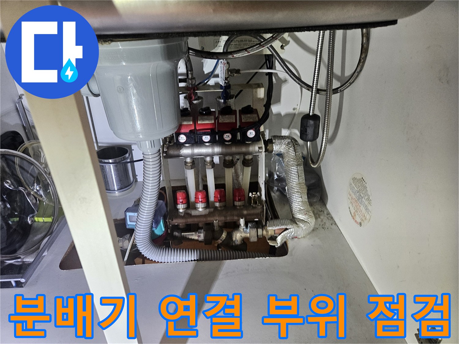 붉은색 손잡이가 달린 분배기 밸브와 은색 호스