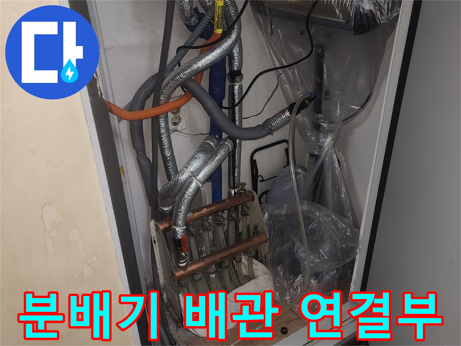 보일러 하부의 은박 보온재로 덮인 배관 및 분배기 상세