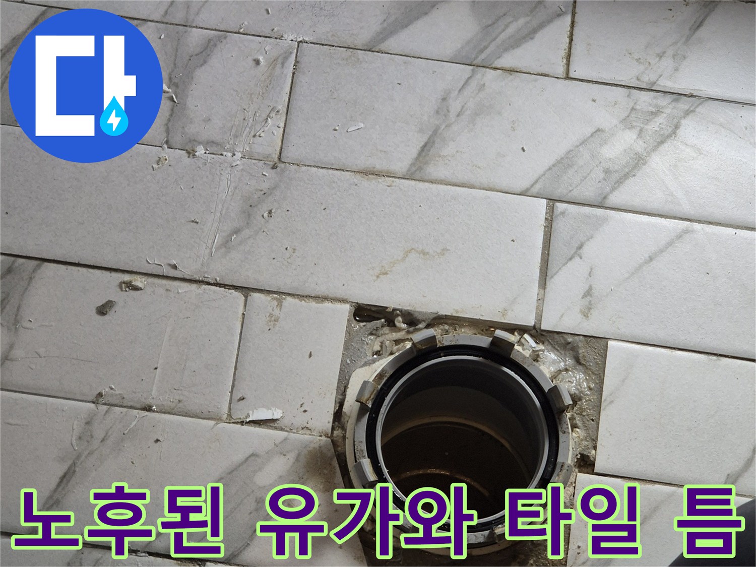 유가 주변의 오염된 타일 줄눈과 벌어진 틈새를 보여줍니다.