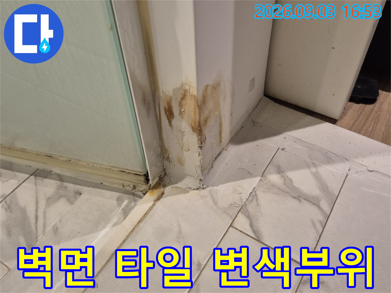 타일과 프레임 사이의 갈색으로 오염된 누수 자국
