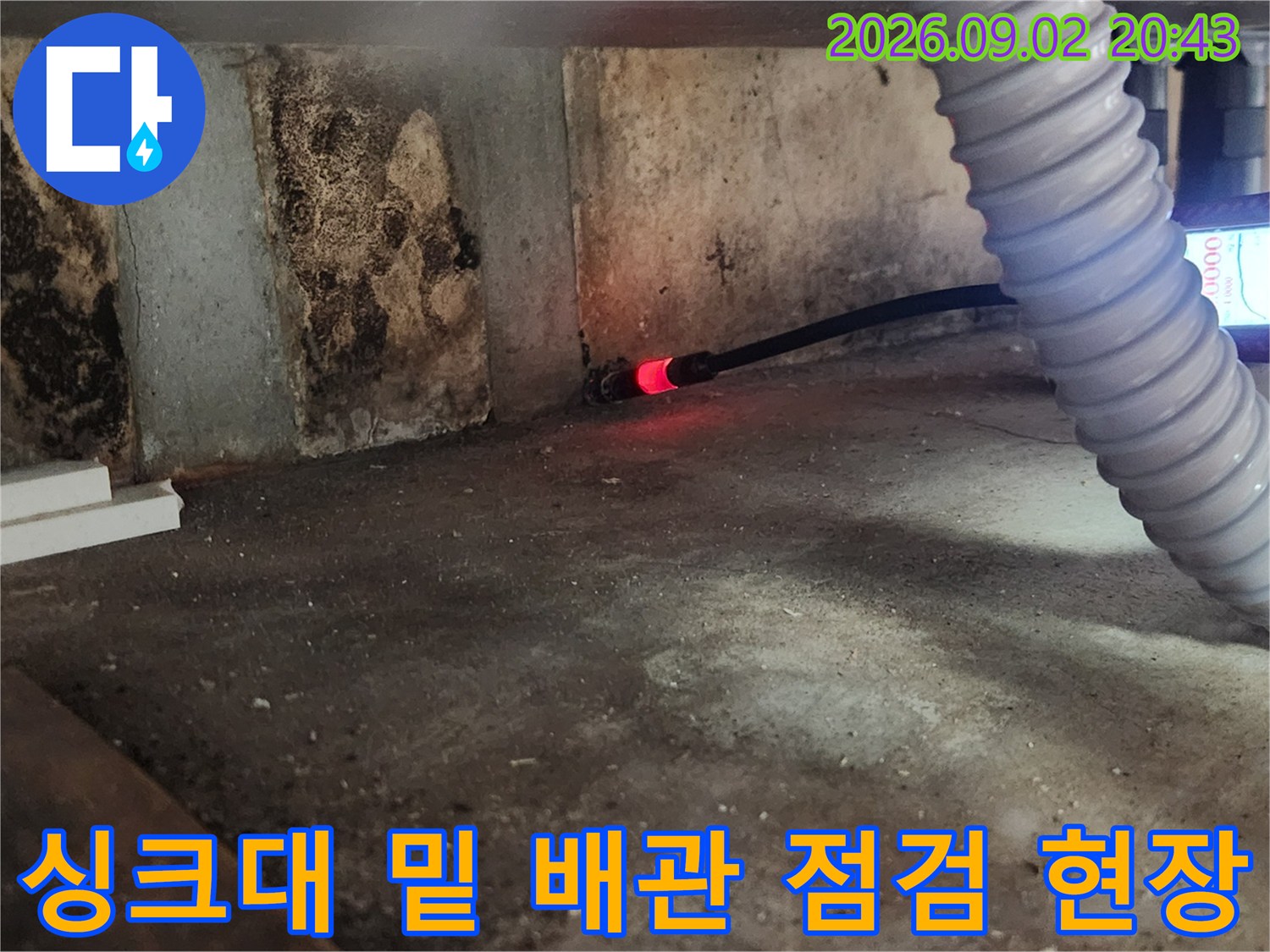 습기가 가득한 벽면과 바닥 사이에서 가스 탐지기로 누수 지점을 검사하고 있습니다.