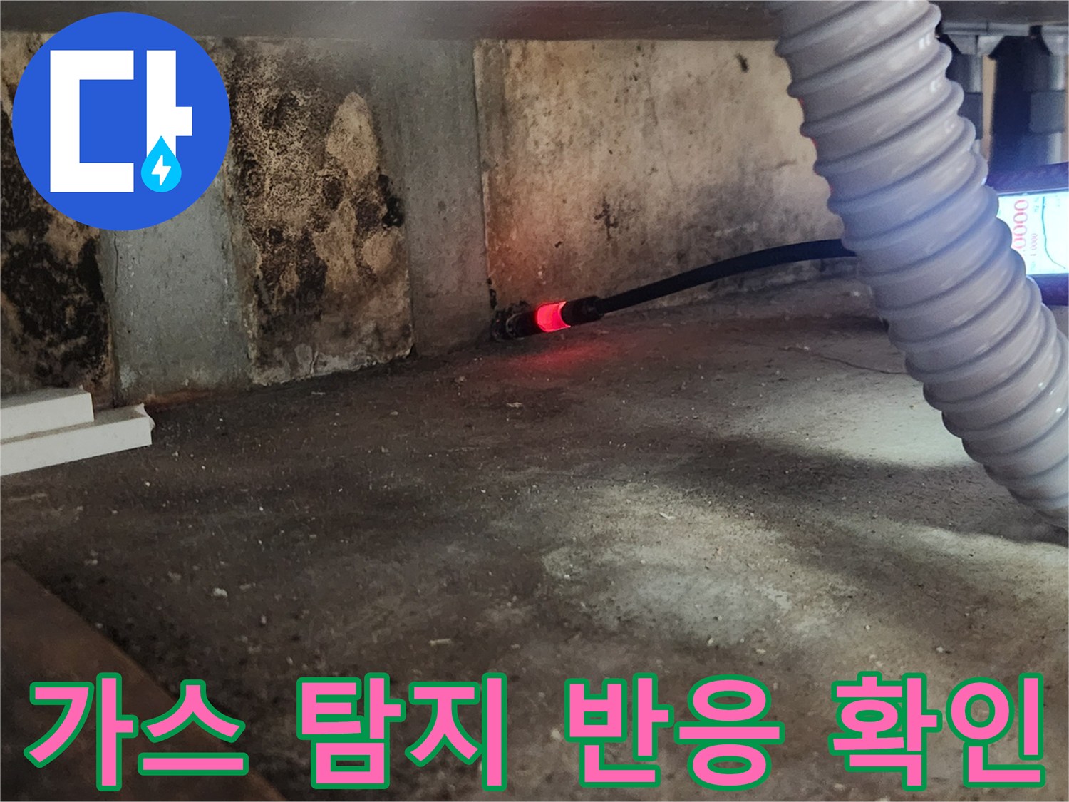 싱크대 하부 공간에서 가스 누출을 확인하기 위해 탐지기를 사용하는 모습