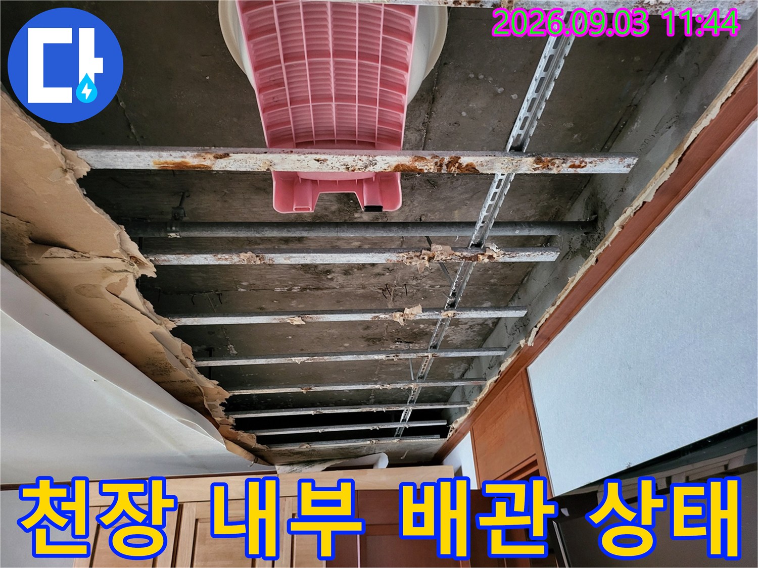 천장 마감재 안쪽의-습기를 머금은 슬래브와 금속 지지대 모습