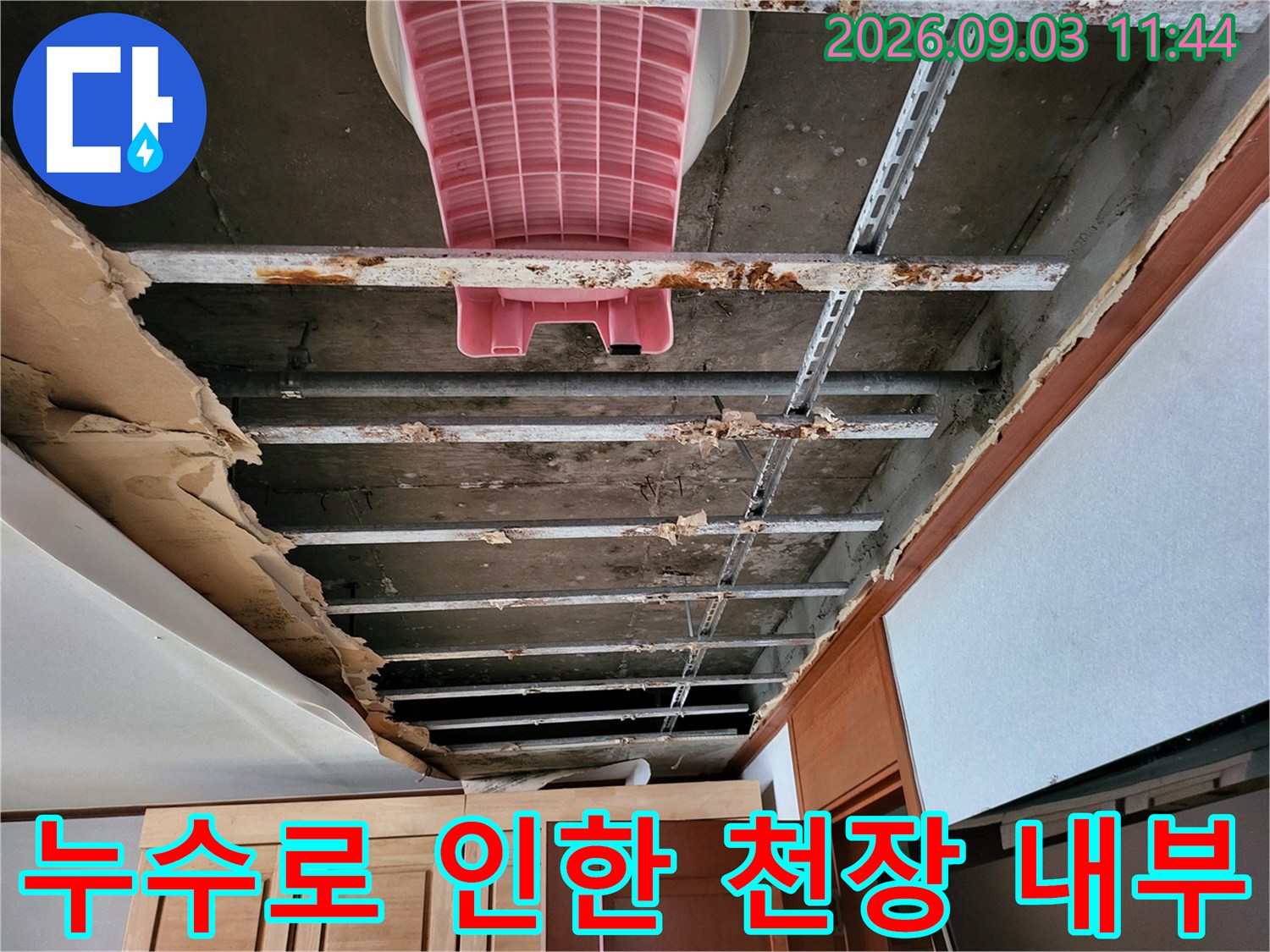 천장 마감재를 제거한 후 드러난 콘크리트 슬래브와 젖어 있는 배관 구조물입니다.