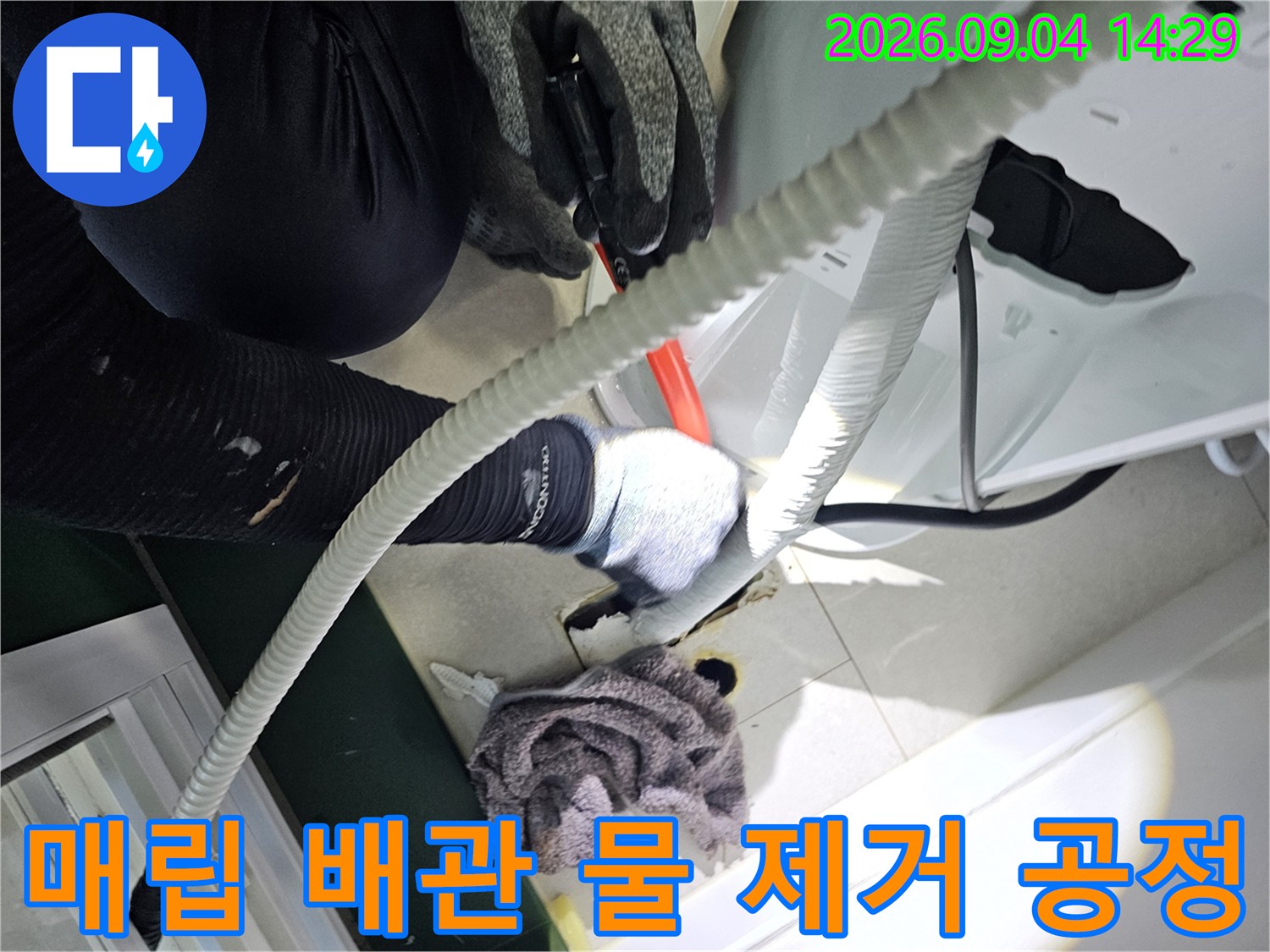 배관의 잔수를 제거하기 위해 호스를 연결하여 작업 중입니다.