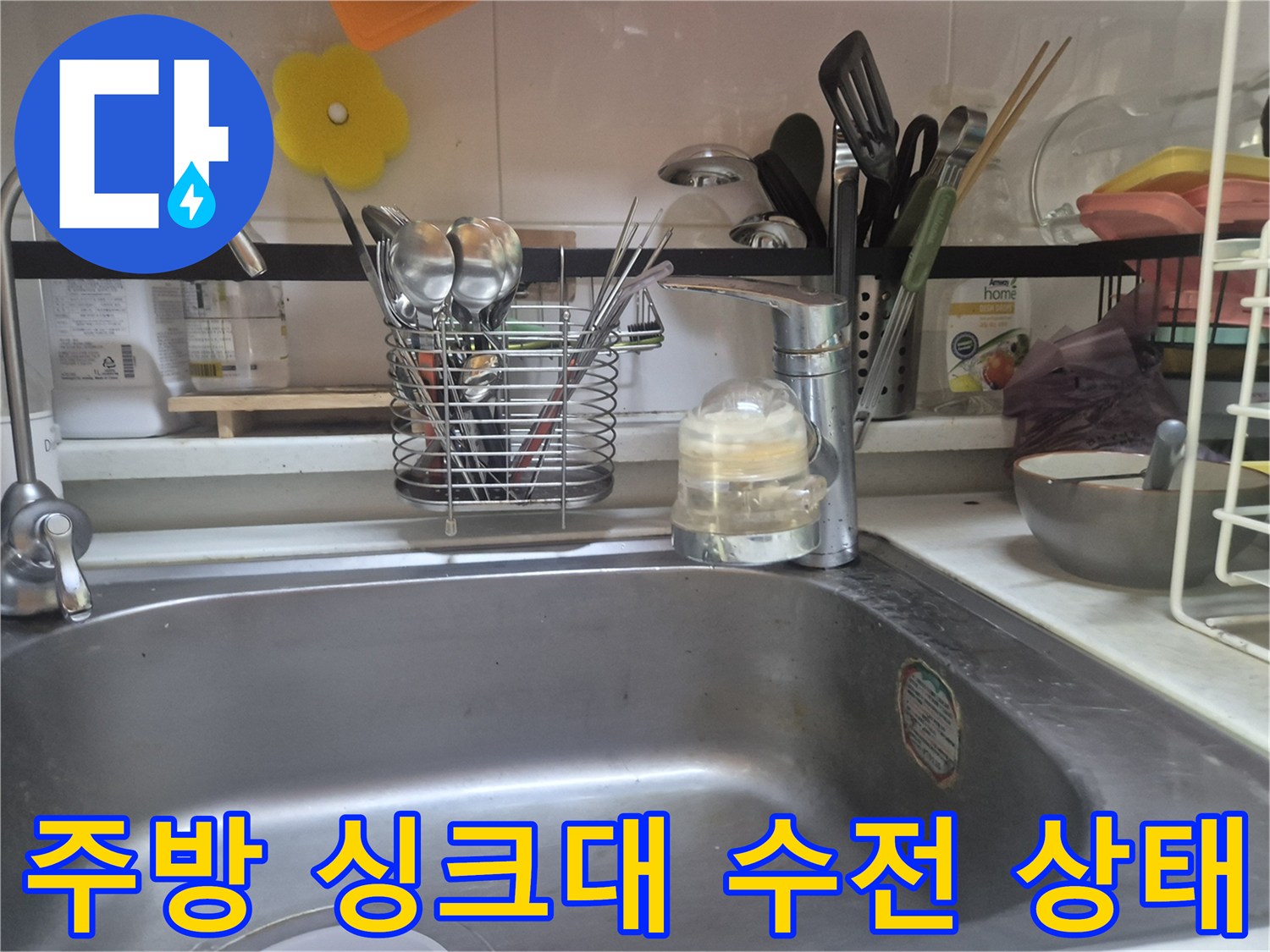점검 중인 싱크대 수전과 주변의 주방 용품들입니다.