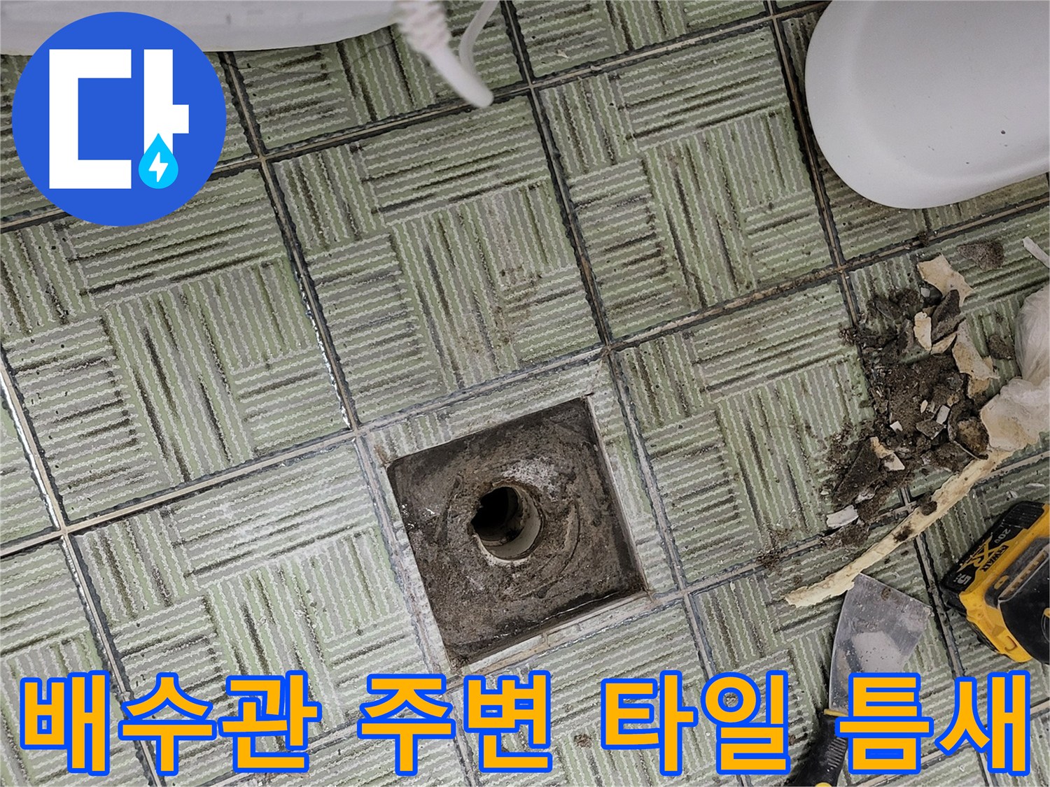 손상된 하수구 주변의 노출된 배관과 도구들