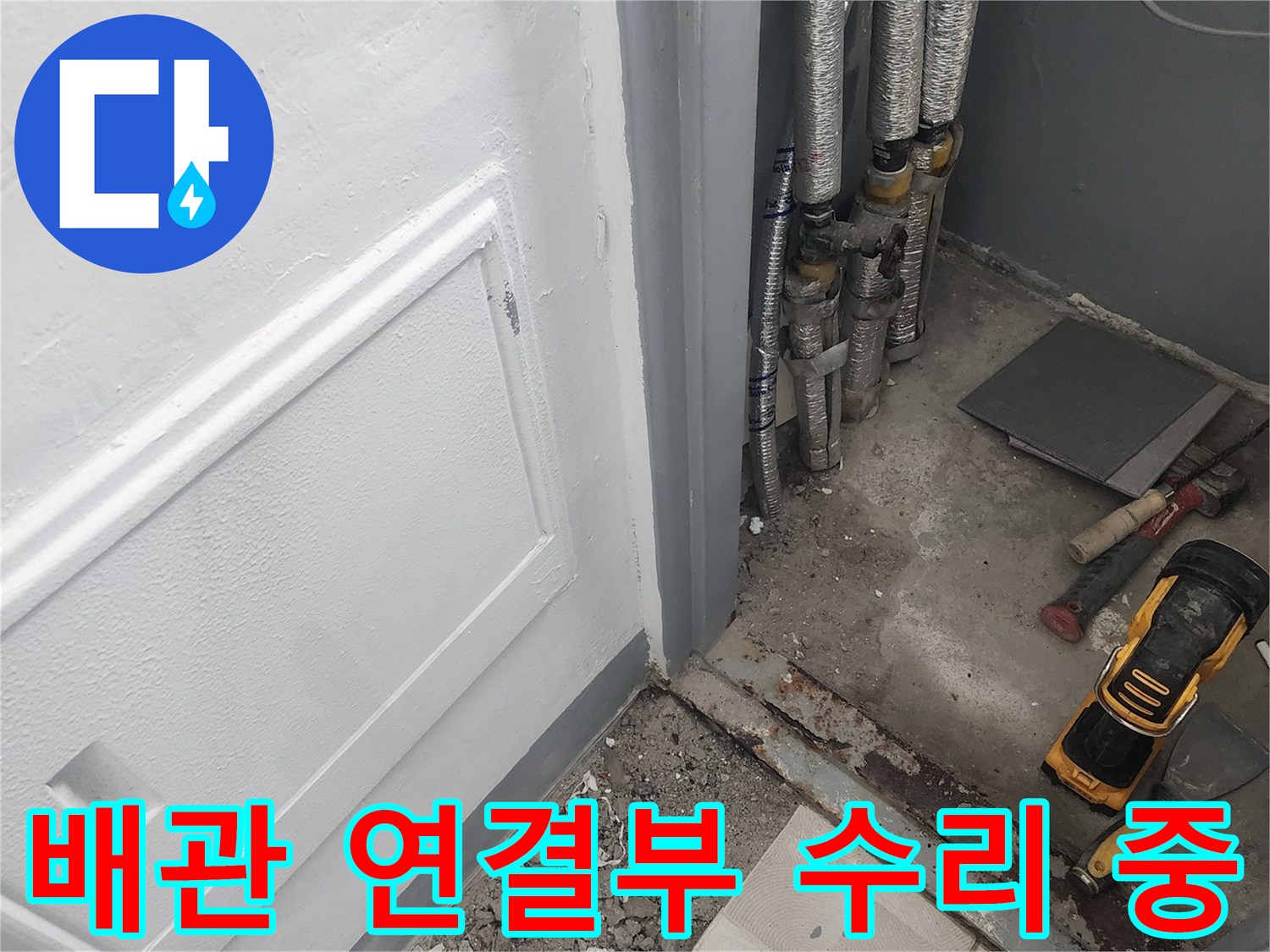 보온재로 감싸진 배관과 작업용 전동 드릴이 보이는 현장입니다.