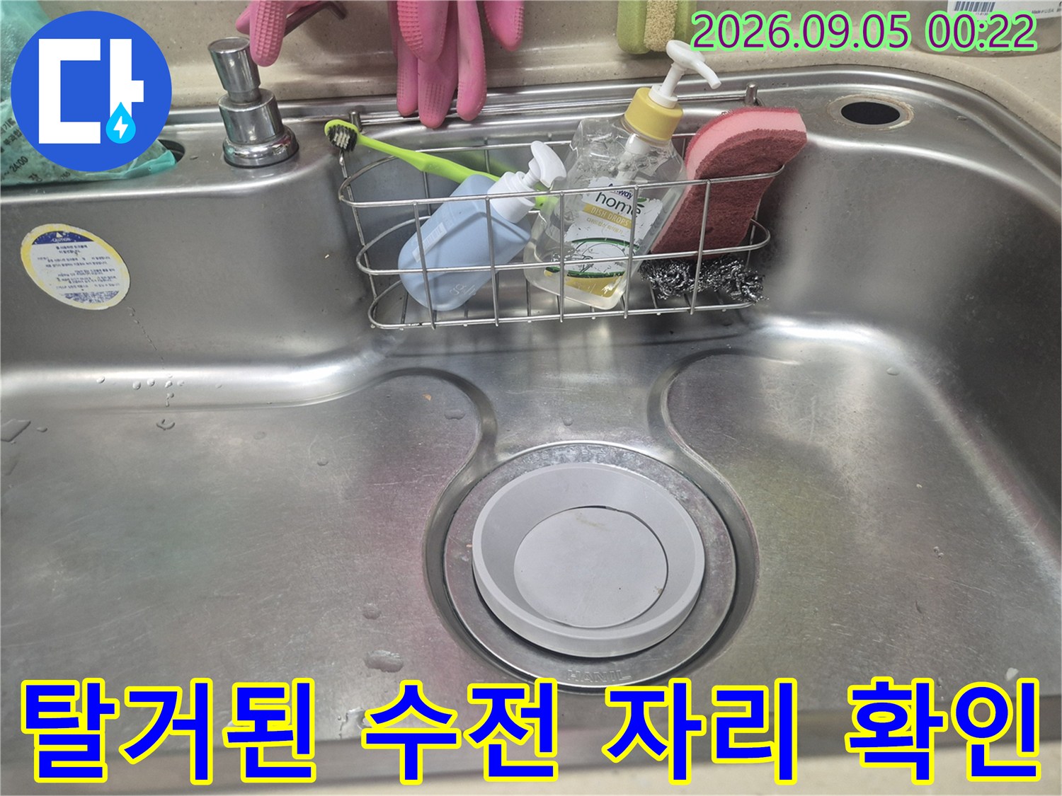 수전이 제거된 싱크대 배수구와 세제 보관함의 모습입니다.