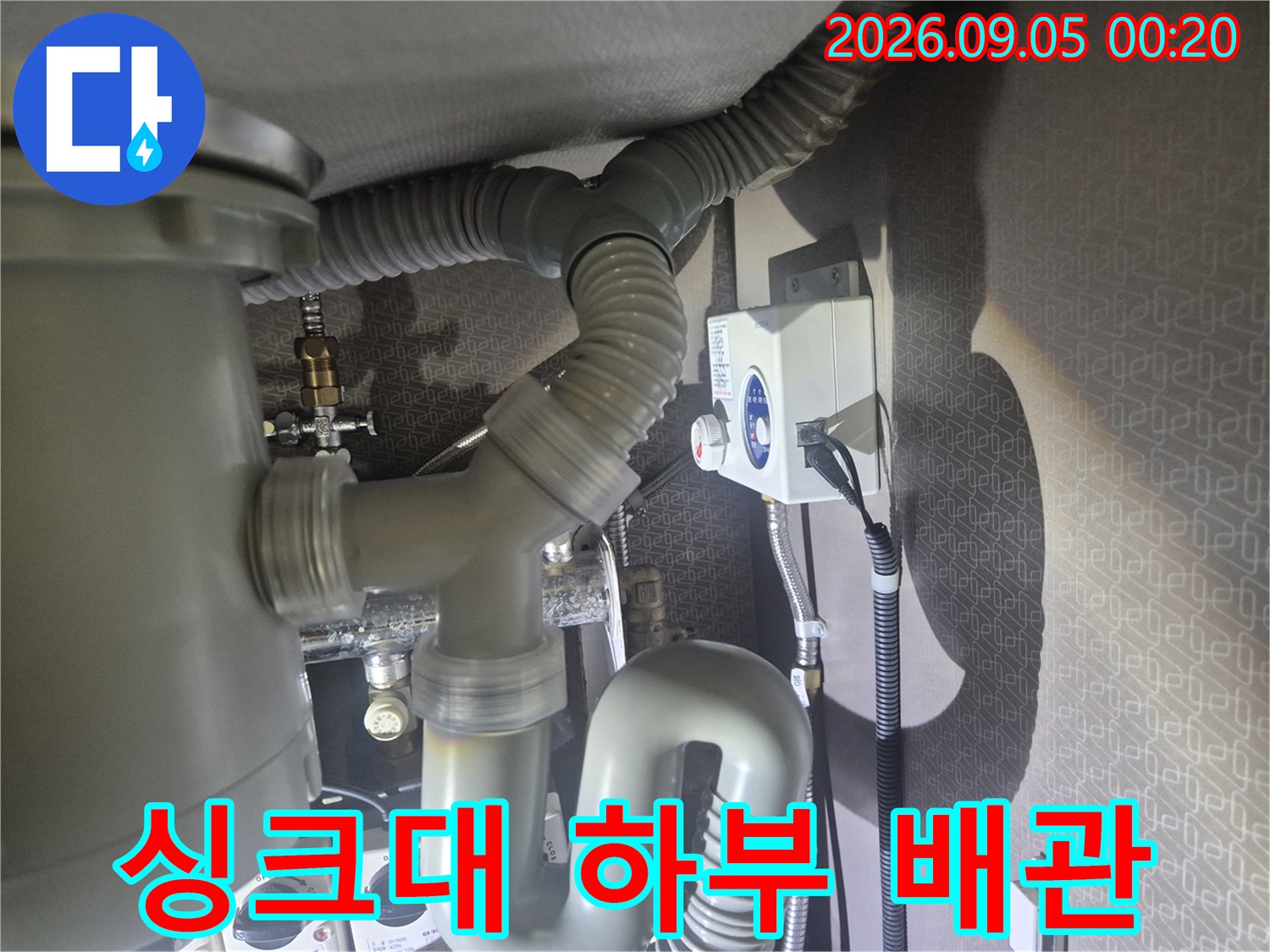 싱크대-밑부분의-회색-배수 호스와-벽면 부속품들
