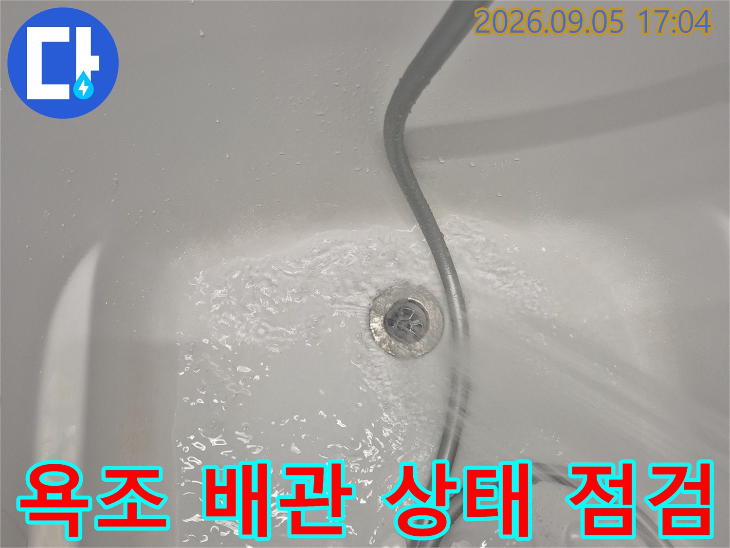 욕조 배수구 근처의 물 고임과 배관 상태를 보여줍니다
