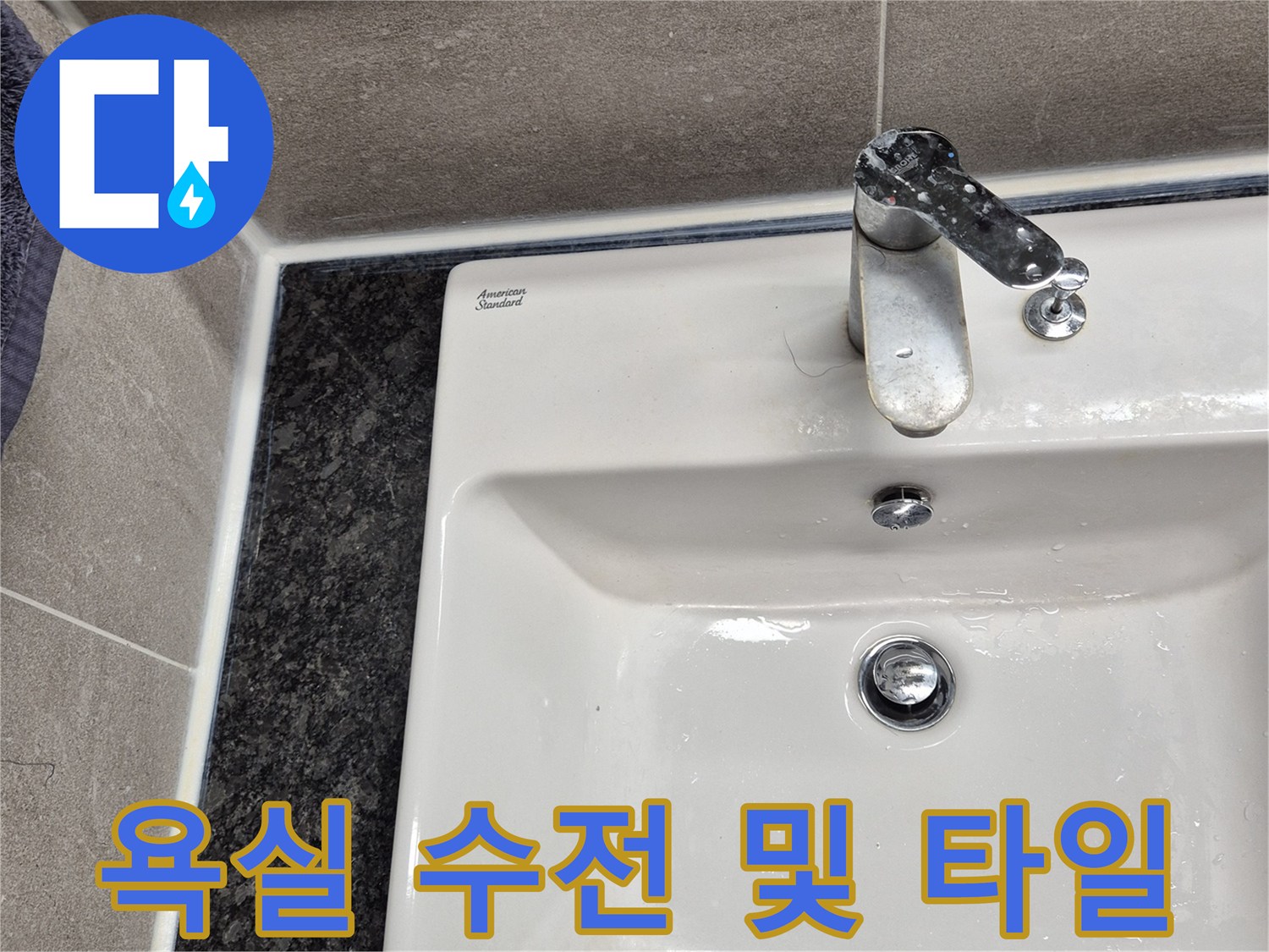 세면대 측면에 설치된 은색 수도꼭지와 벽면 타일 사진입니다.