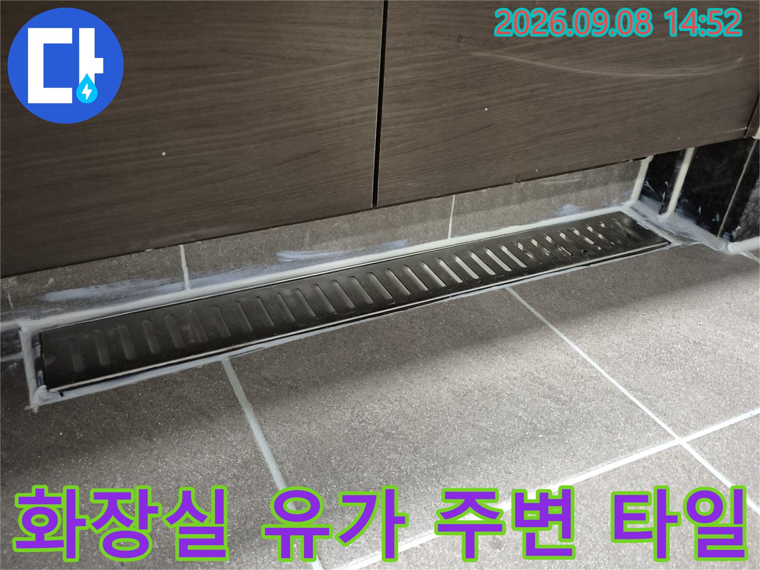 화장실 배수구 유가와 옆면 타일의 정렬 상태를 촬영한 사진입니다.