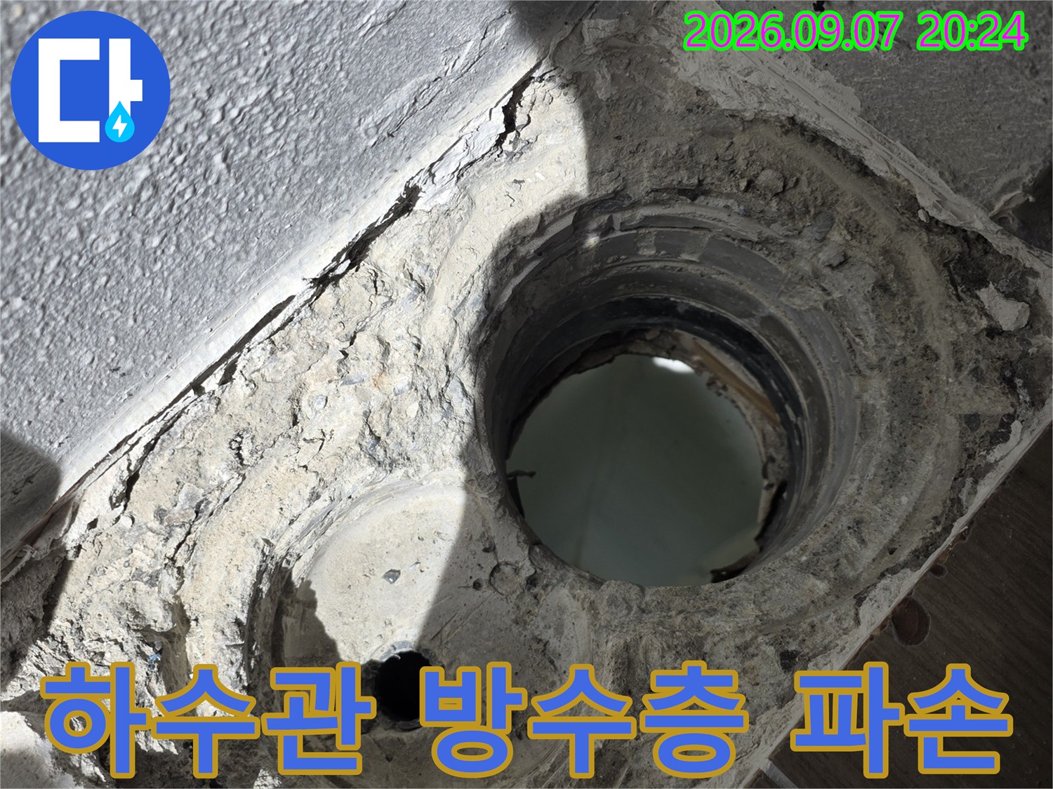 배수구 주변의 갈라진 마감재와 노출된 배관