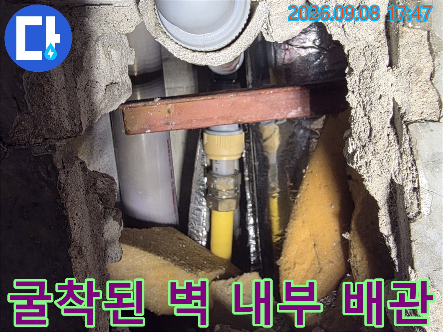 벽을 파내어 드러난-수도 배관의-연결 부위와 주변 자재들