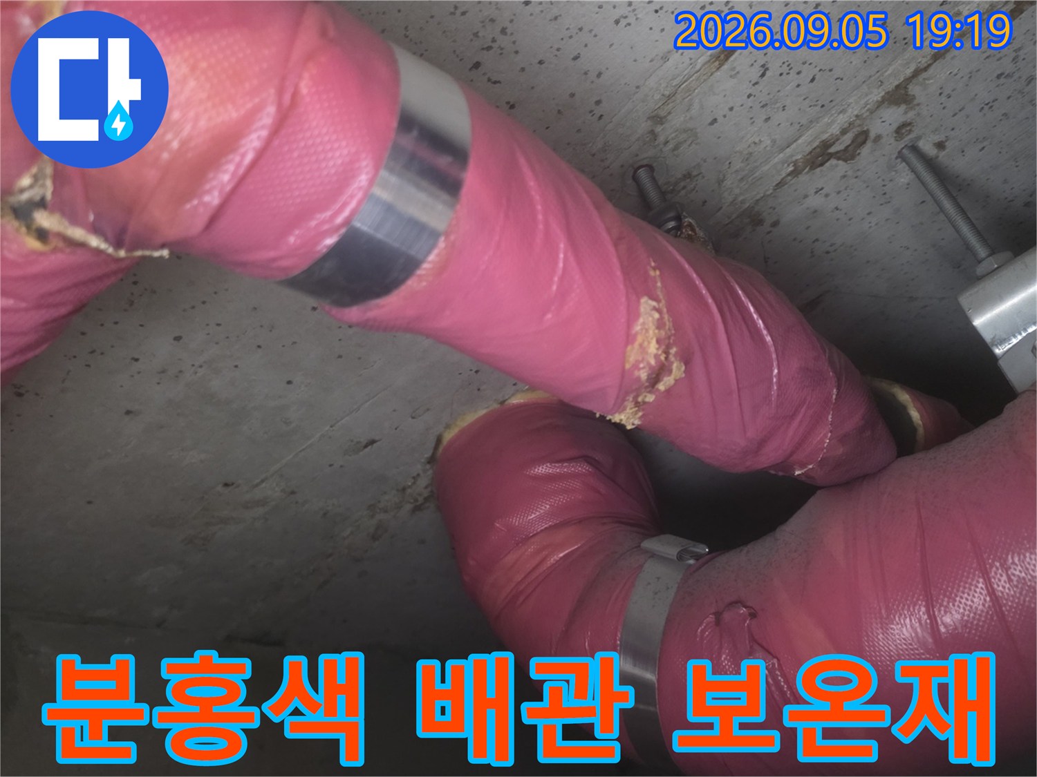 화장실 천장 내부-분홍색 보온재로 감싸진 배관의 연결 부위