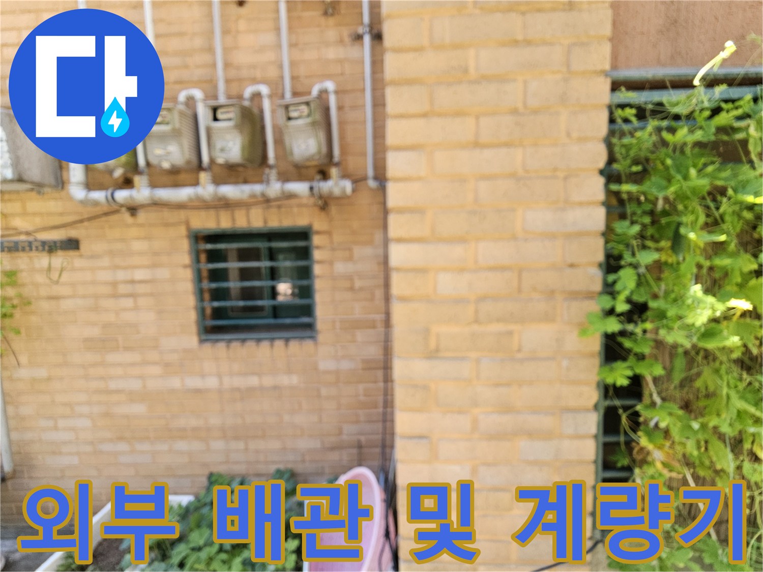 황색 벽돌 외벽에 설치된 여러 개의 수도 계량기 장치입니다.