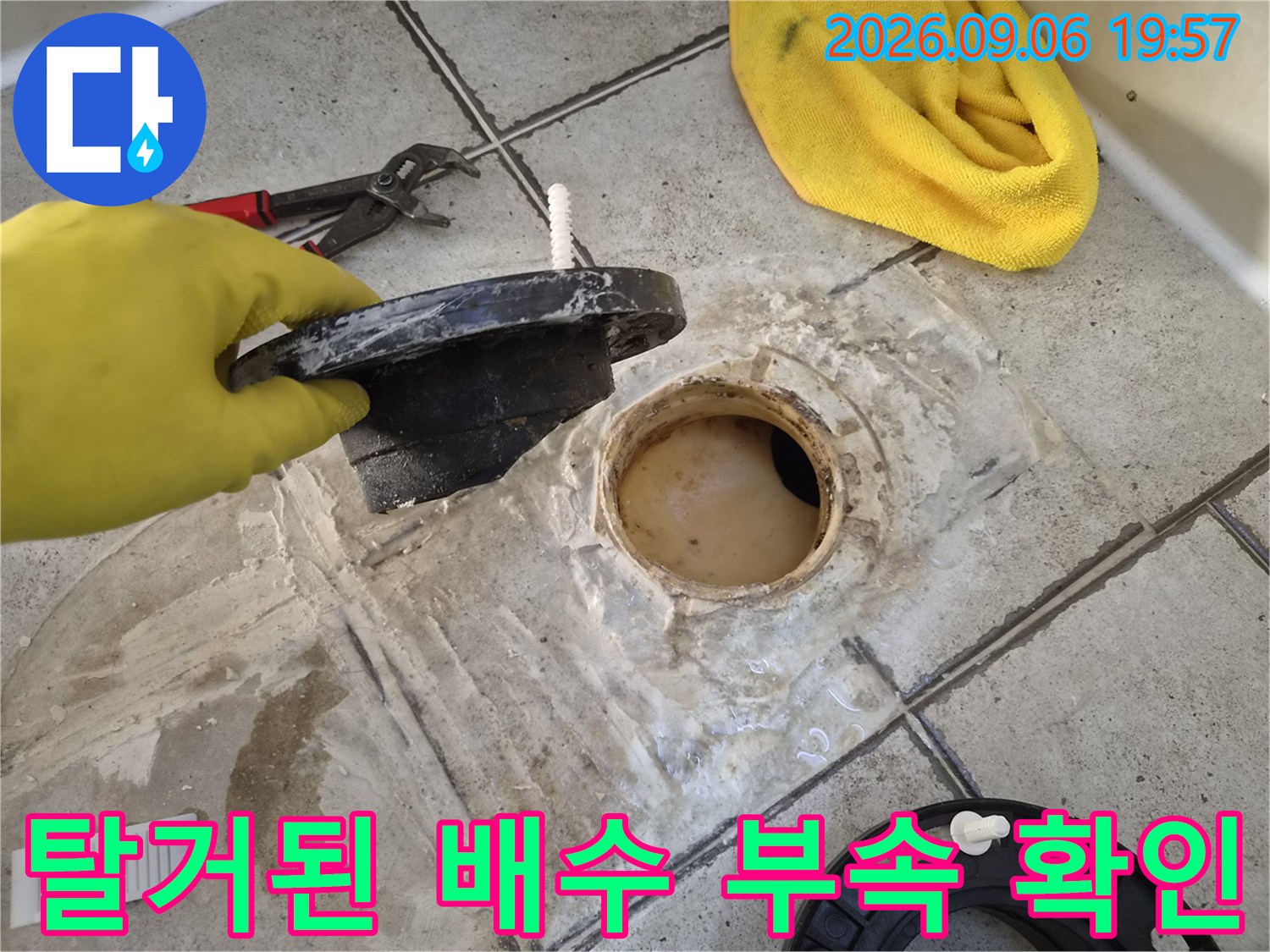 배수구 캡을 들고 있는 손과 드러난 배수관 입구의 모습입니다.