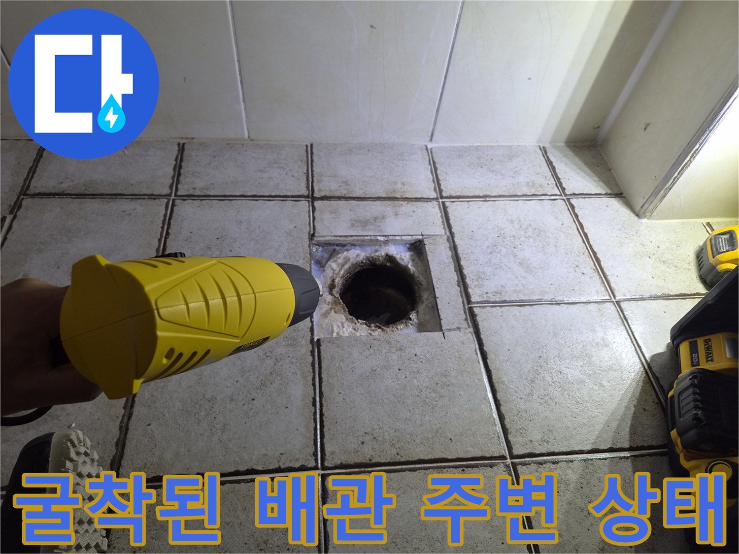 타일 아래 노출된 배관 부위 - 누수 원인 파악을 위한 굴착 작업
