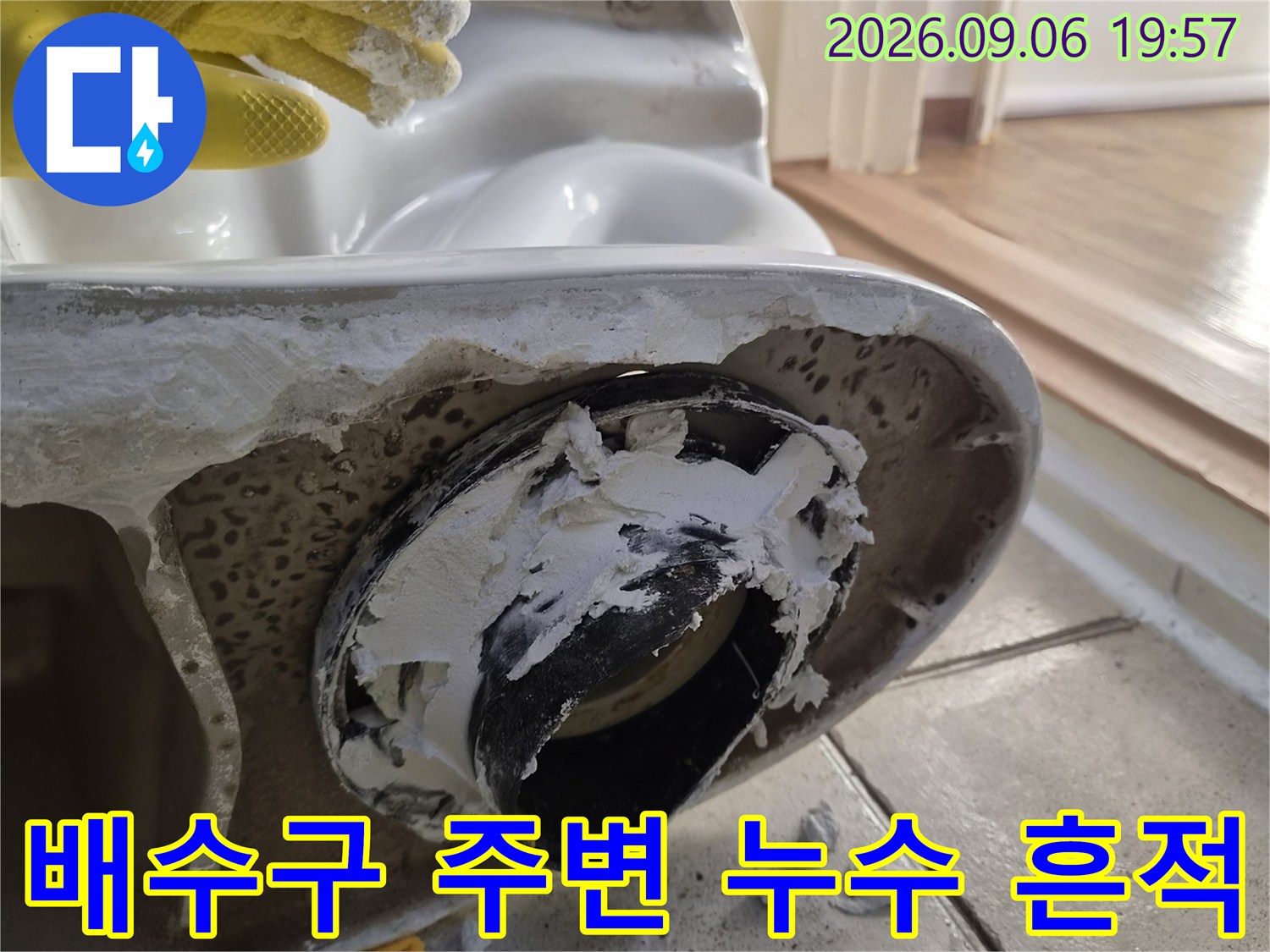 탈거된 배관 부속 주위의 하얀 이물질과 젖은 타일 모습
