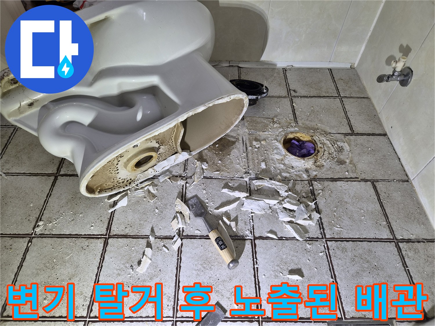 탈거된 양변기 뒤로 보이는 오수관과 파손된 바닥 타일 부위